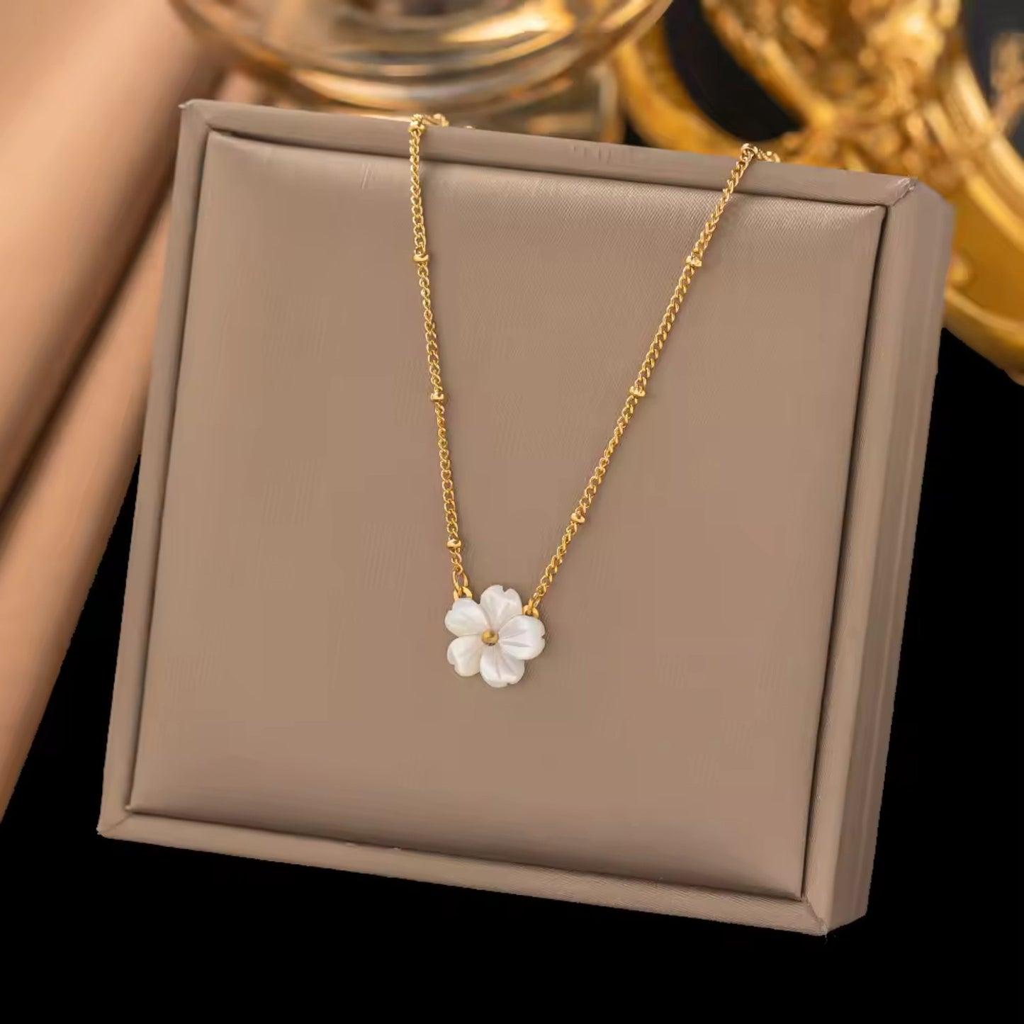 Close-up of the Blossom Beauty Necklace showcasing the lustrous mother of pearl flower pendant with a golden center.