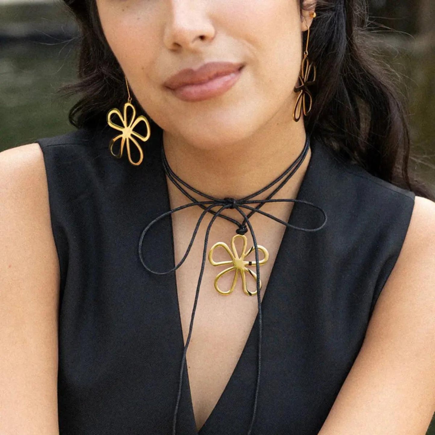 Blossom Bloom Necklace & Earrings featuring a gold-plated chain with a delicate flower pendant, styled elegantly on a model.