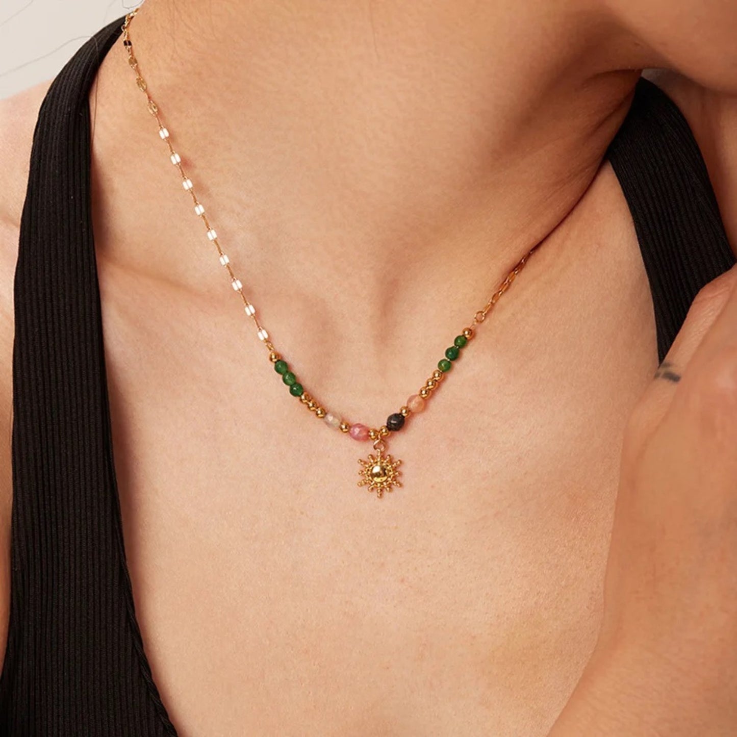 Close-up on a model of the Boho Sun Pendant Necklace showcasing its vibrant semi-precious stones and gold-plated sun pendant.