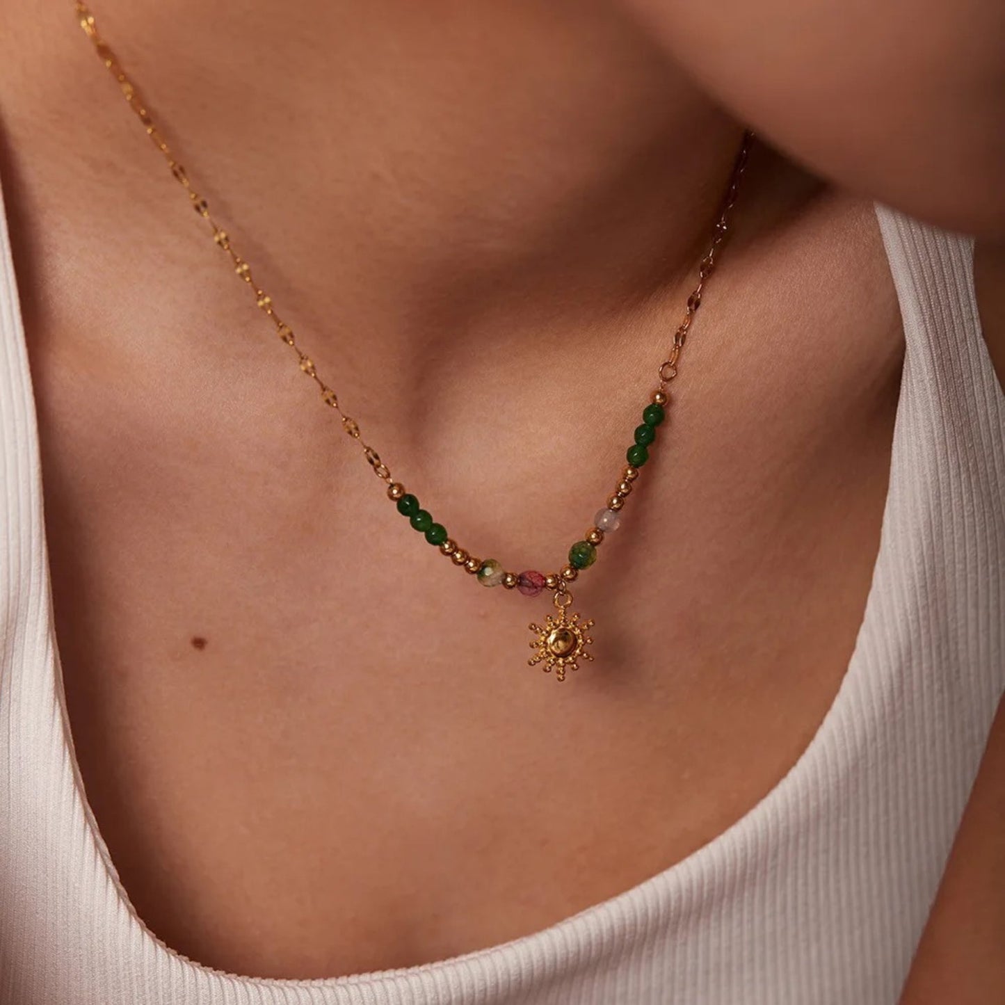 Boho Sun Pendant Necklace featuring green and orange semi-precious stones with an 18K gold-plated sun pendant, styled on a model for a bohemian look.