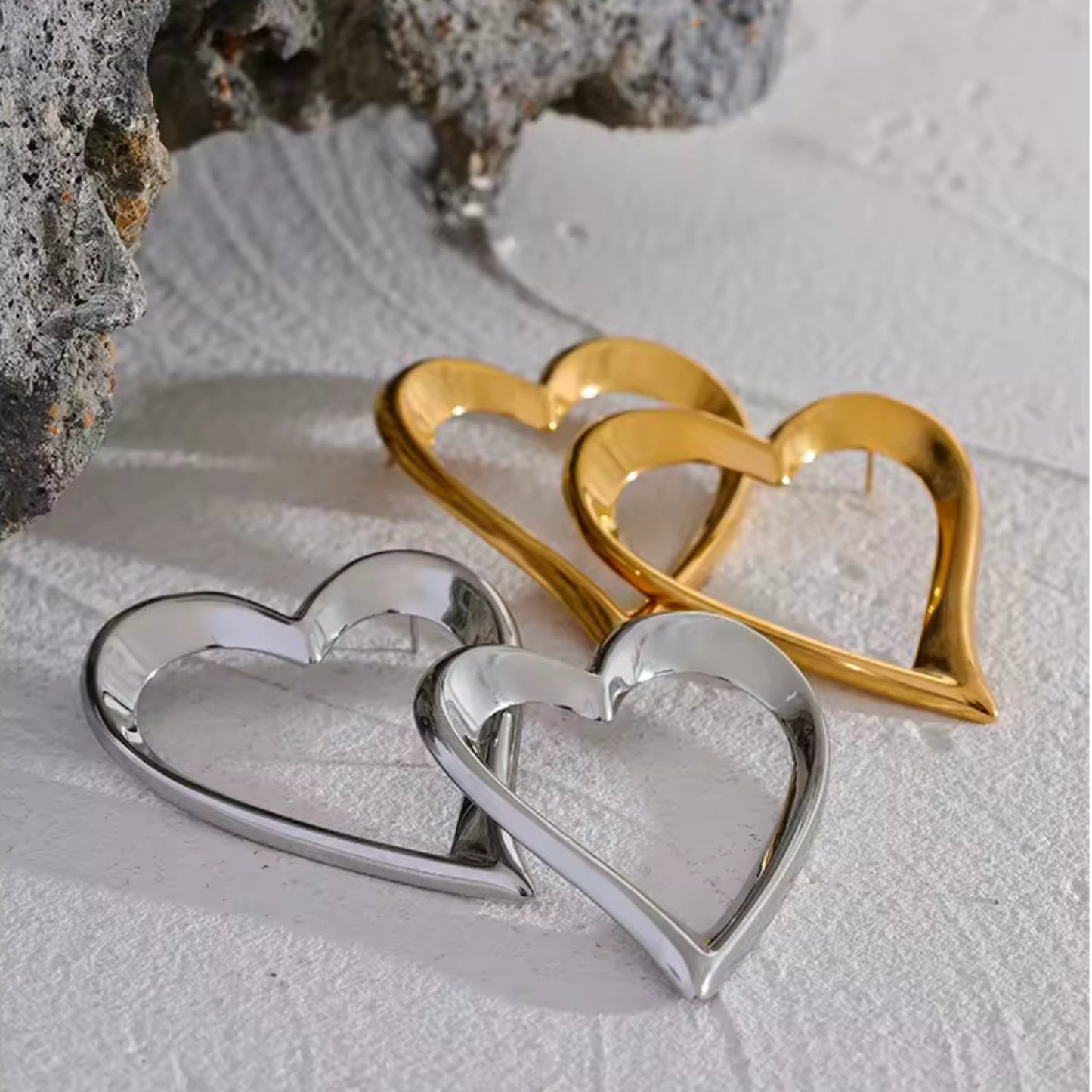 Close-up of the Bold Open-Heart Statement Earrings in 18K gold-plated and Silver-plated stainless steel, showcasing their minimalistic heart shape.