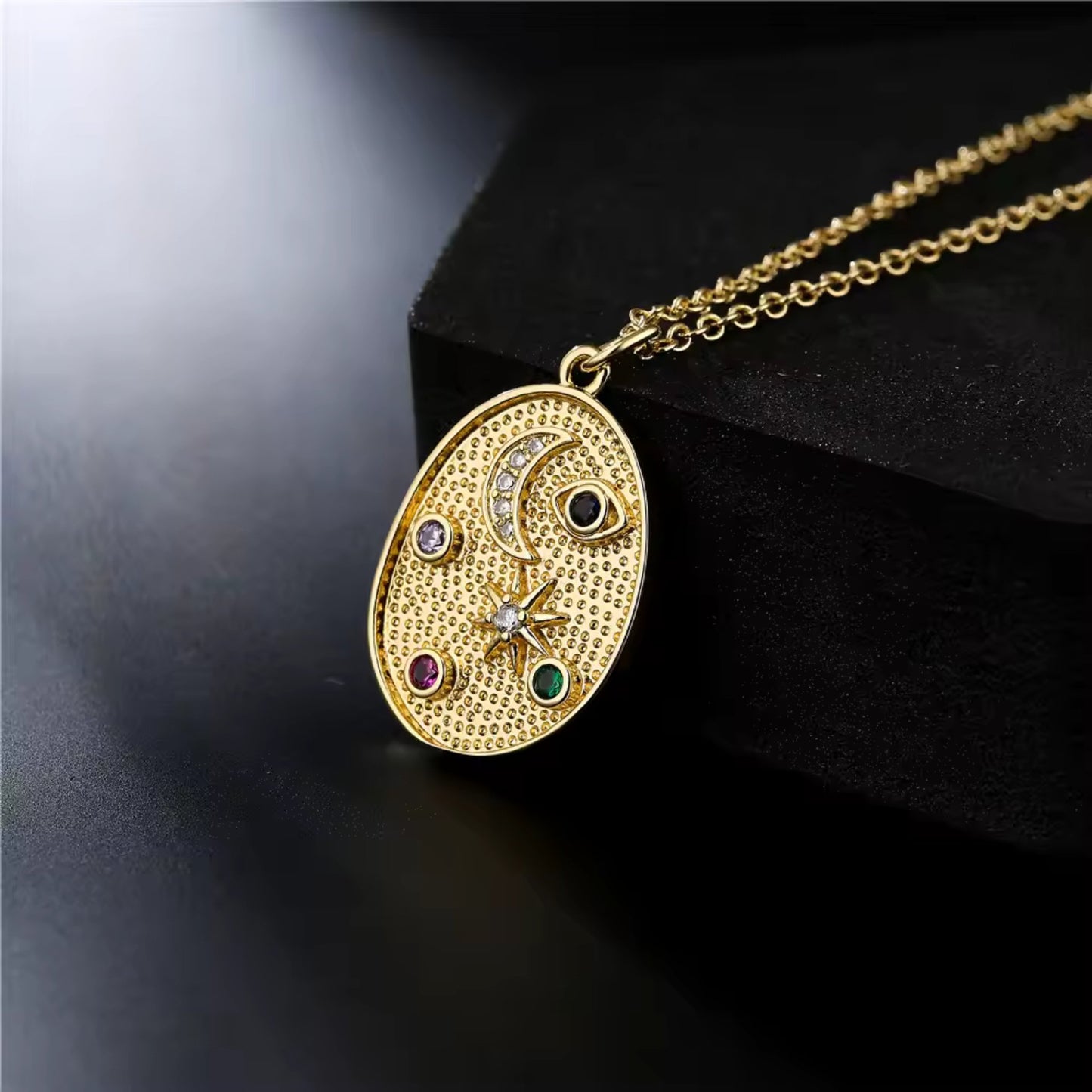 Close-up of the Celestial Charm Pendant Necklace showcasing engraved stars and moons accented with vibrant cubic zirconia stones.