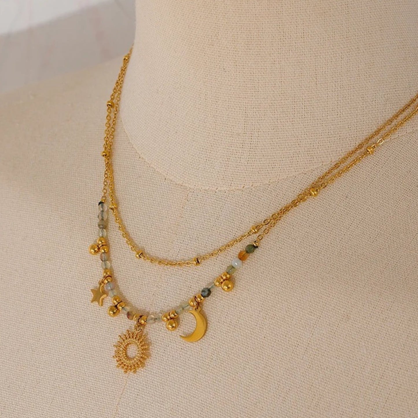 Close-up of the Celestial Harmony Charm Necklace showcasing celestial charms and delicate faceted bead accents.