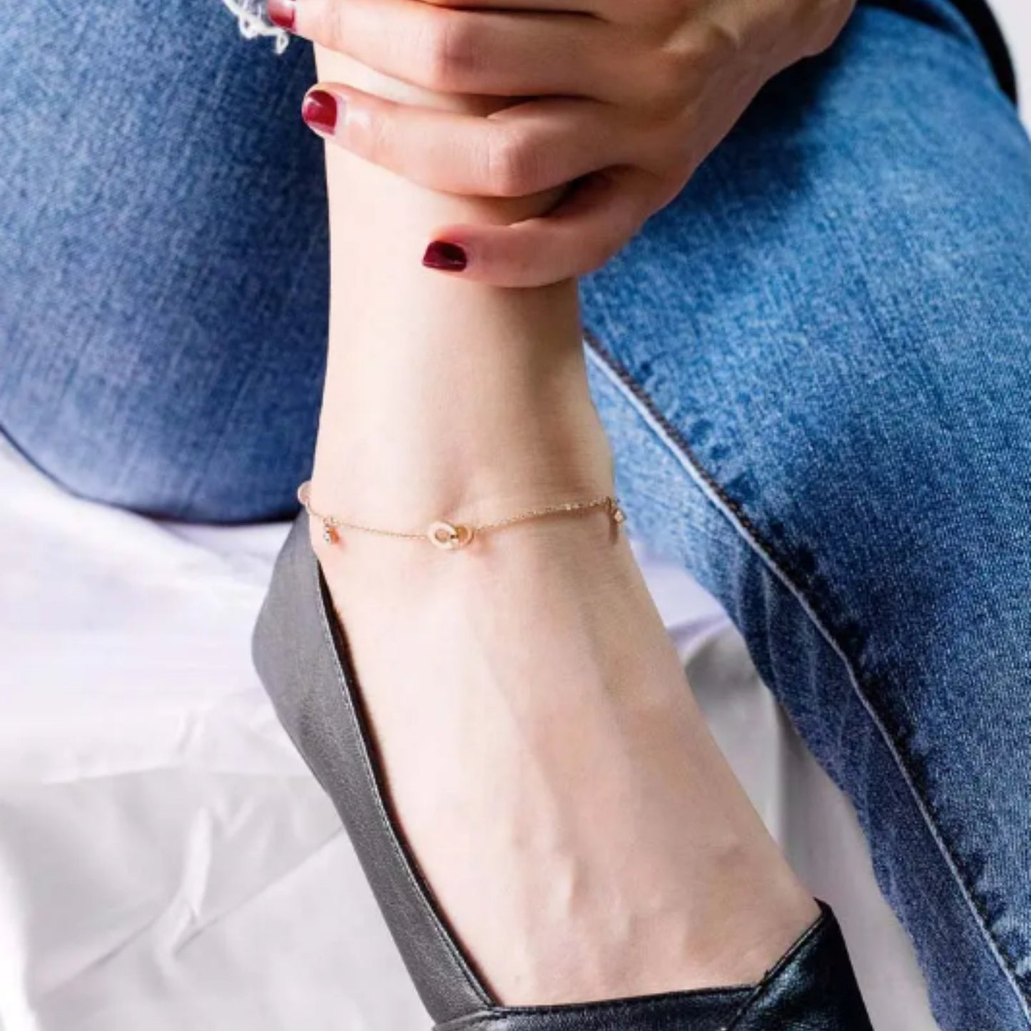 Circle of Love Anklet styled on an ankle, highlighting its elegant 18K rose gold finish and delicate charm details.