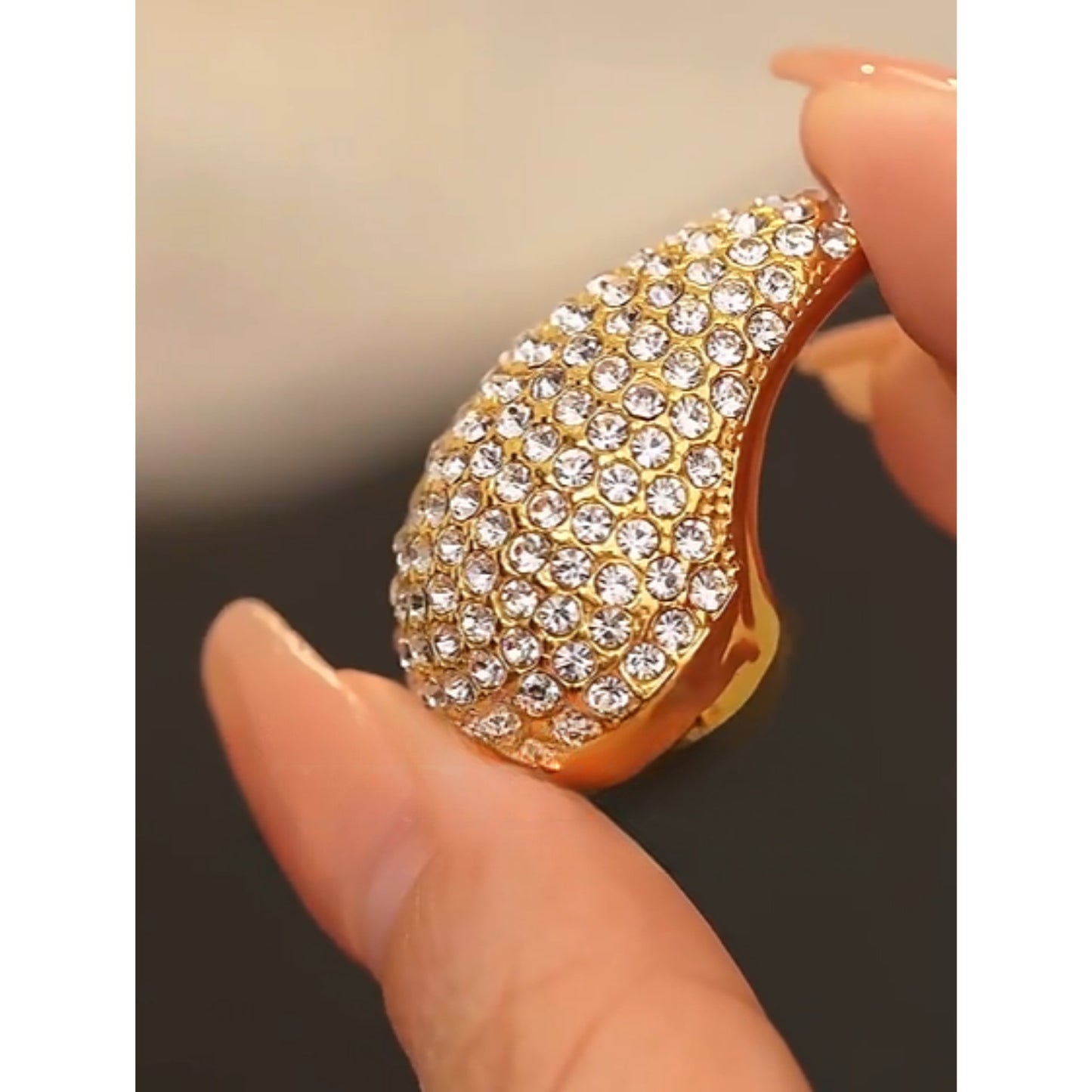 Model holding the Crystal Embellished Gold Teardrop Earrings, showcasing their timeless elegance.