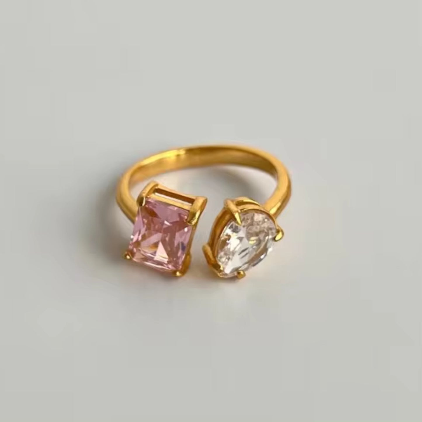 Close-up of the Dual Delight Zircon Ring showcasing the pink and clear zircon combination on a polished 18K gold-plated band.