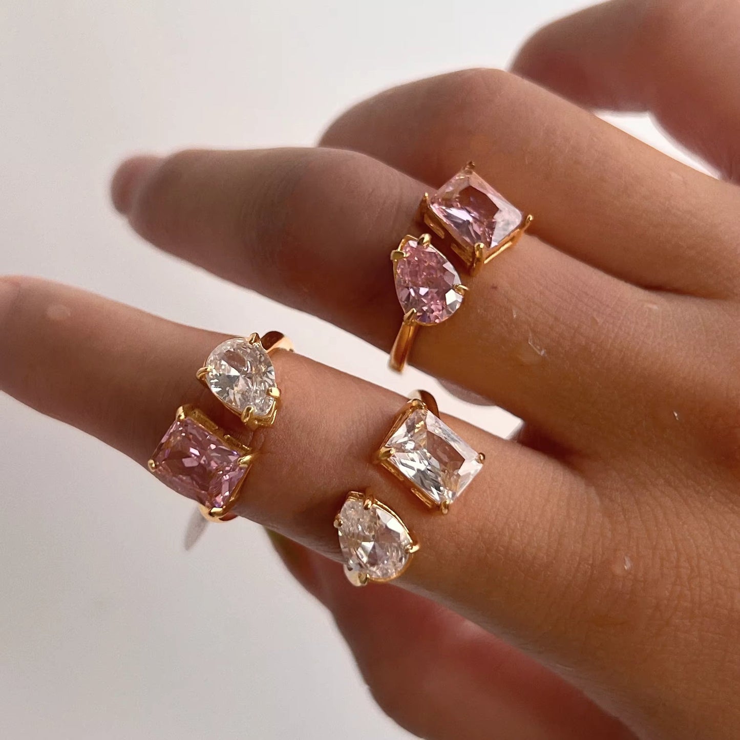 Model wearing the Dual Delight Zircon Ring featuring a water drop and square zircon in pink and white hues.