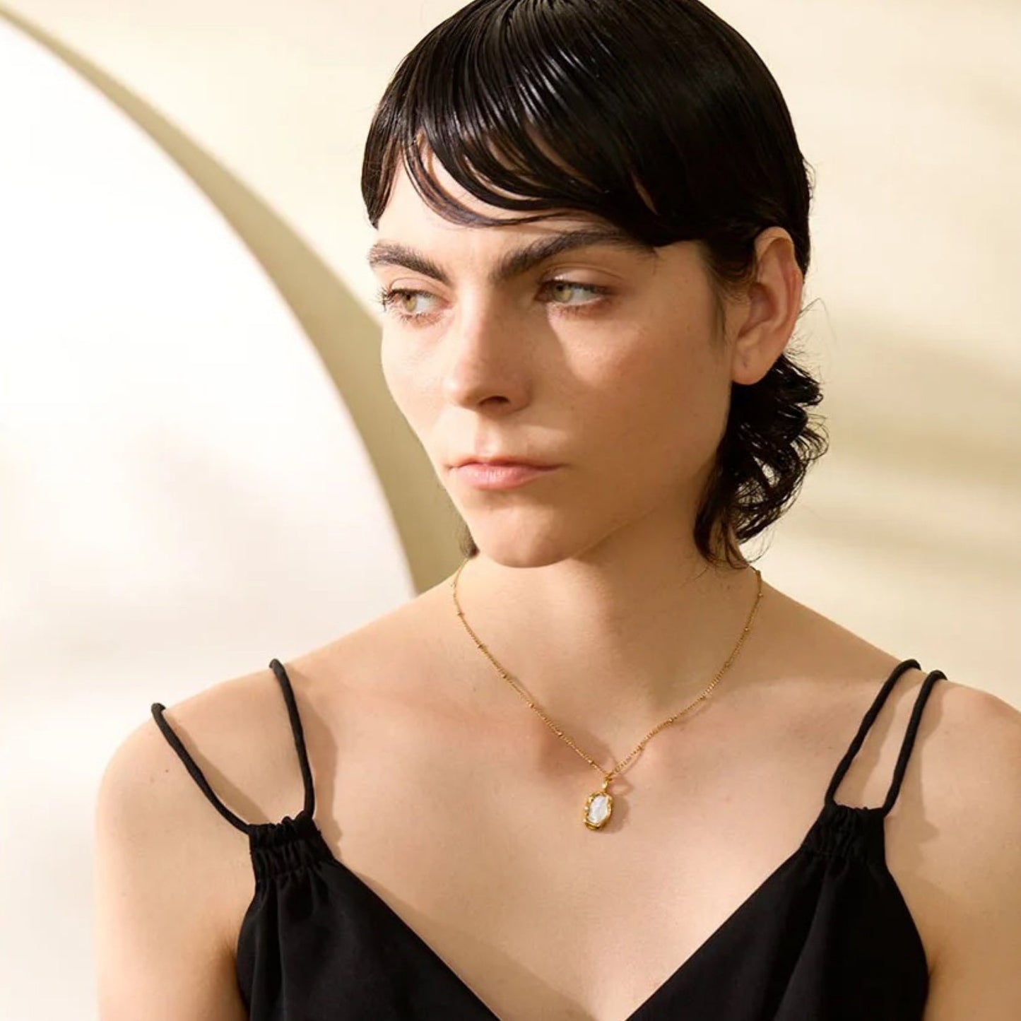 Side view of the Dual-Sided Shell Pendant Necklace, displaying the natural shell pendant and 18K PVD gold-plated finish styled on a model.