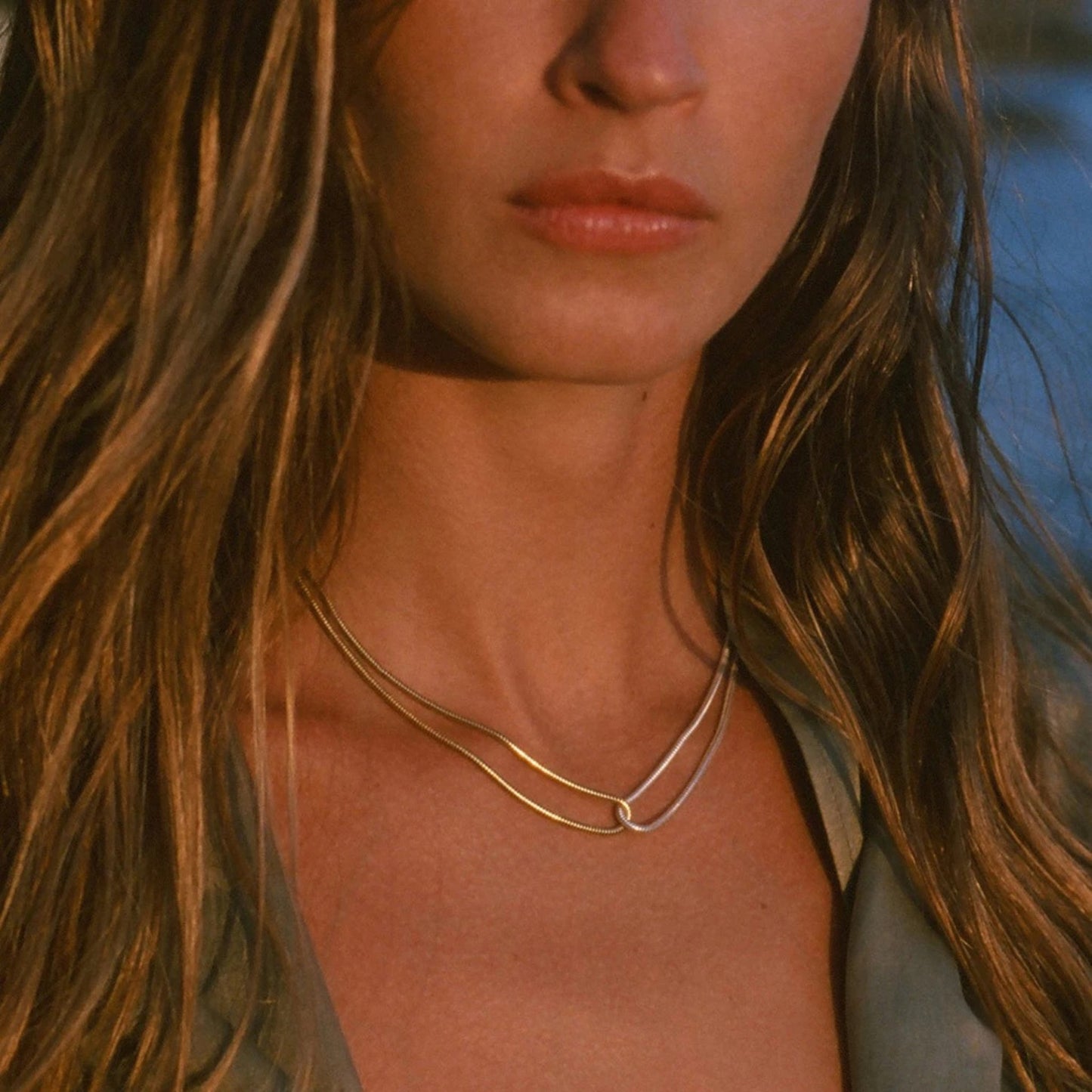Close-up of the unique blade snake chain showcasing the dual-tone gold and silver sides styled on a model.