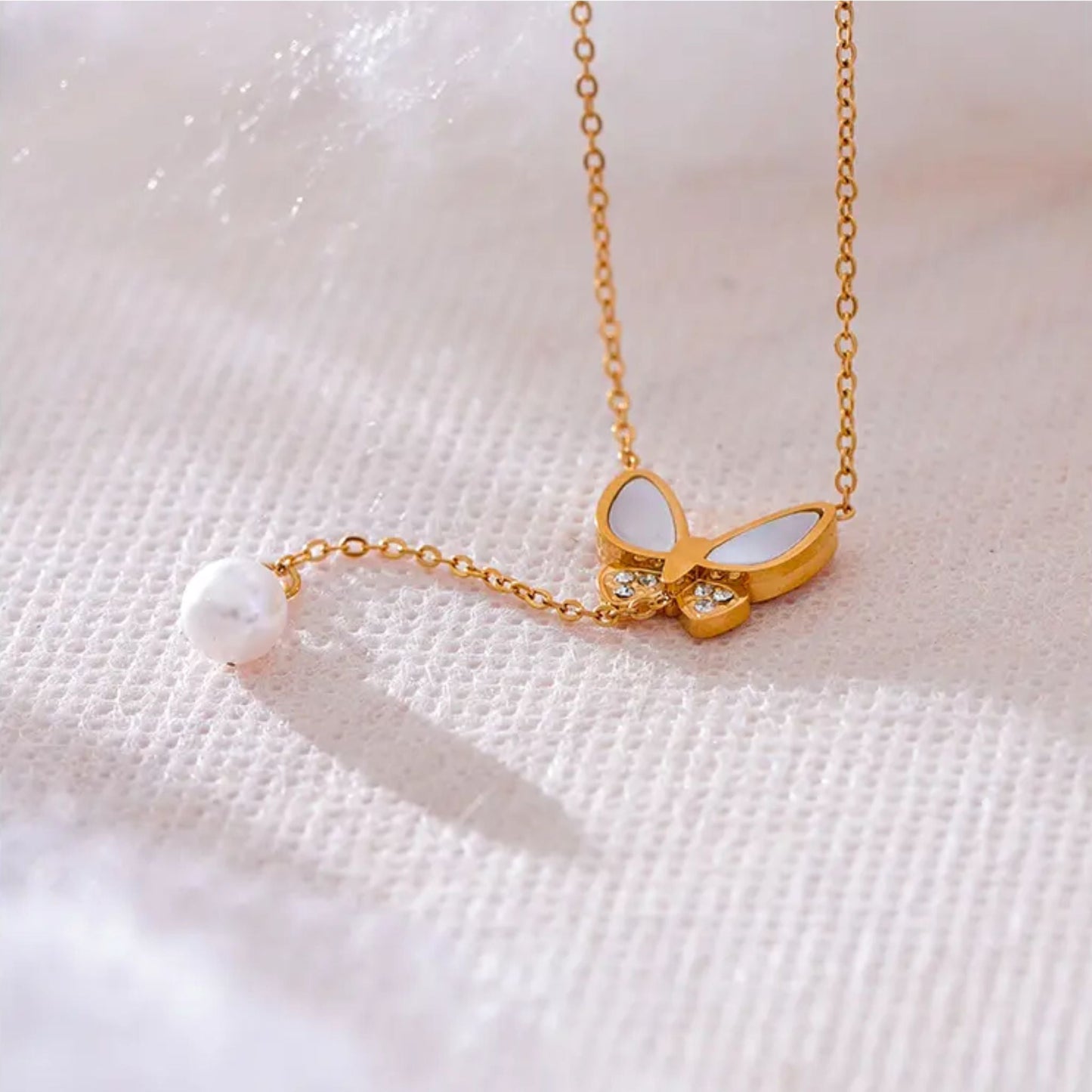Close-Up of Gold-Plated Necklace with Butterfly and Pearl Drop
