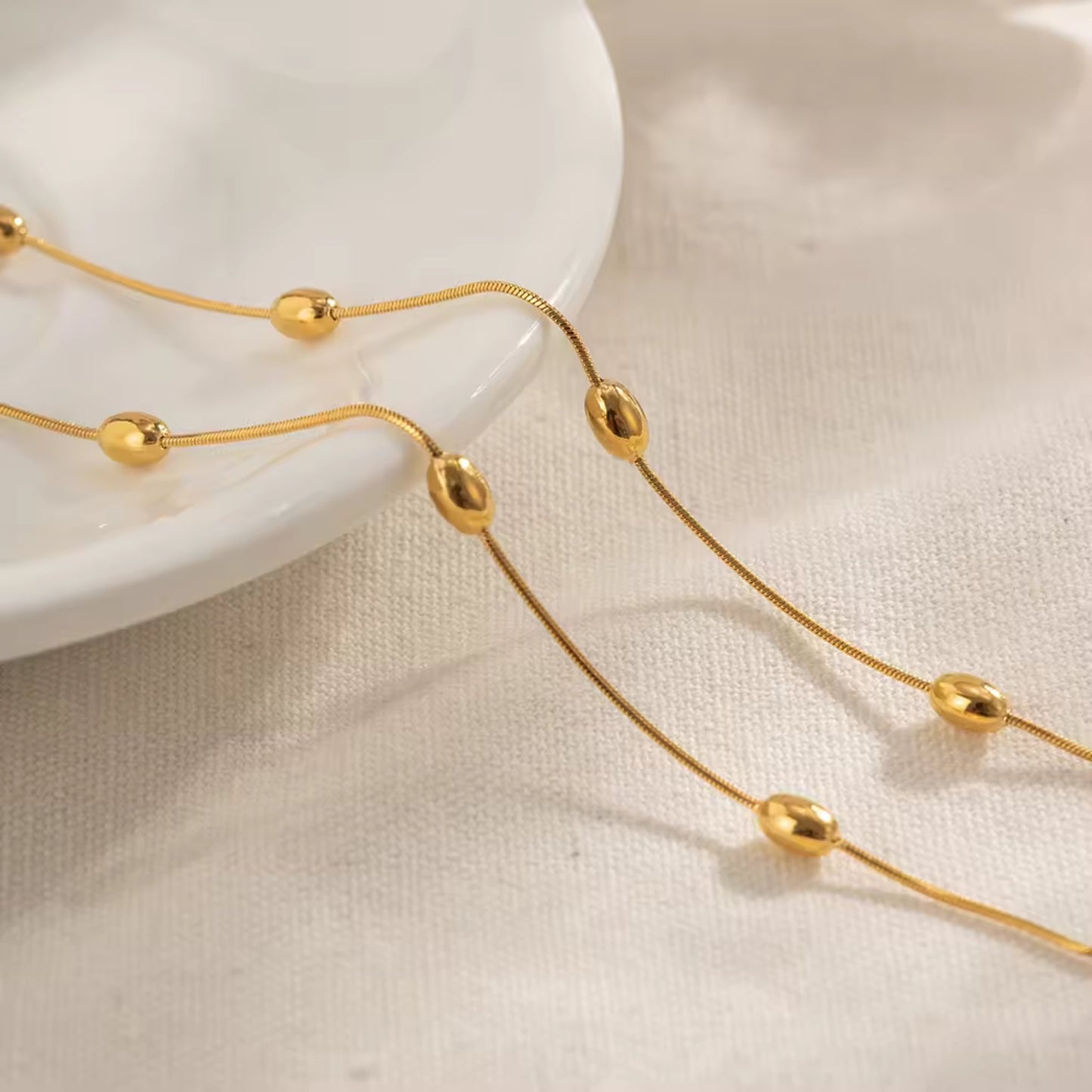 Close-up of the delicate gold beads on the slender chain of the Elegant Gold Beaded Belly Chain.