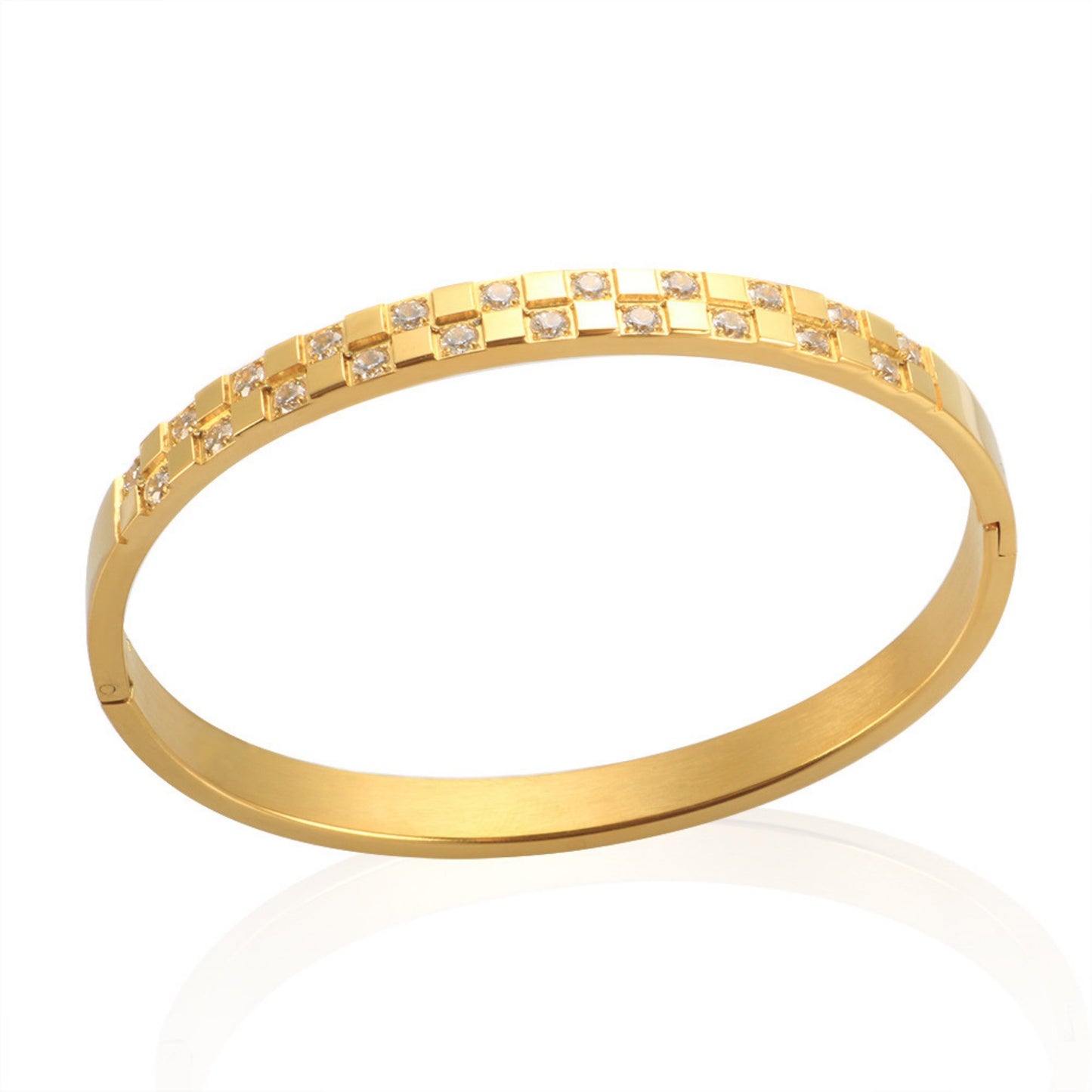 Close-up of a gold-plated stainless steel cuff bracelet with a checkered pattern of cubic zirconia stones, displayed on a white background.