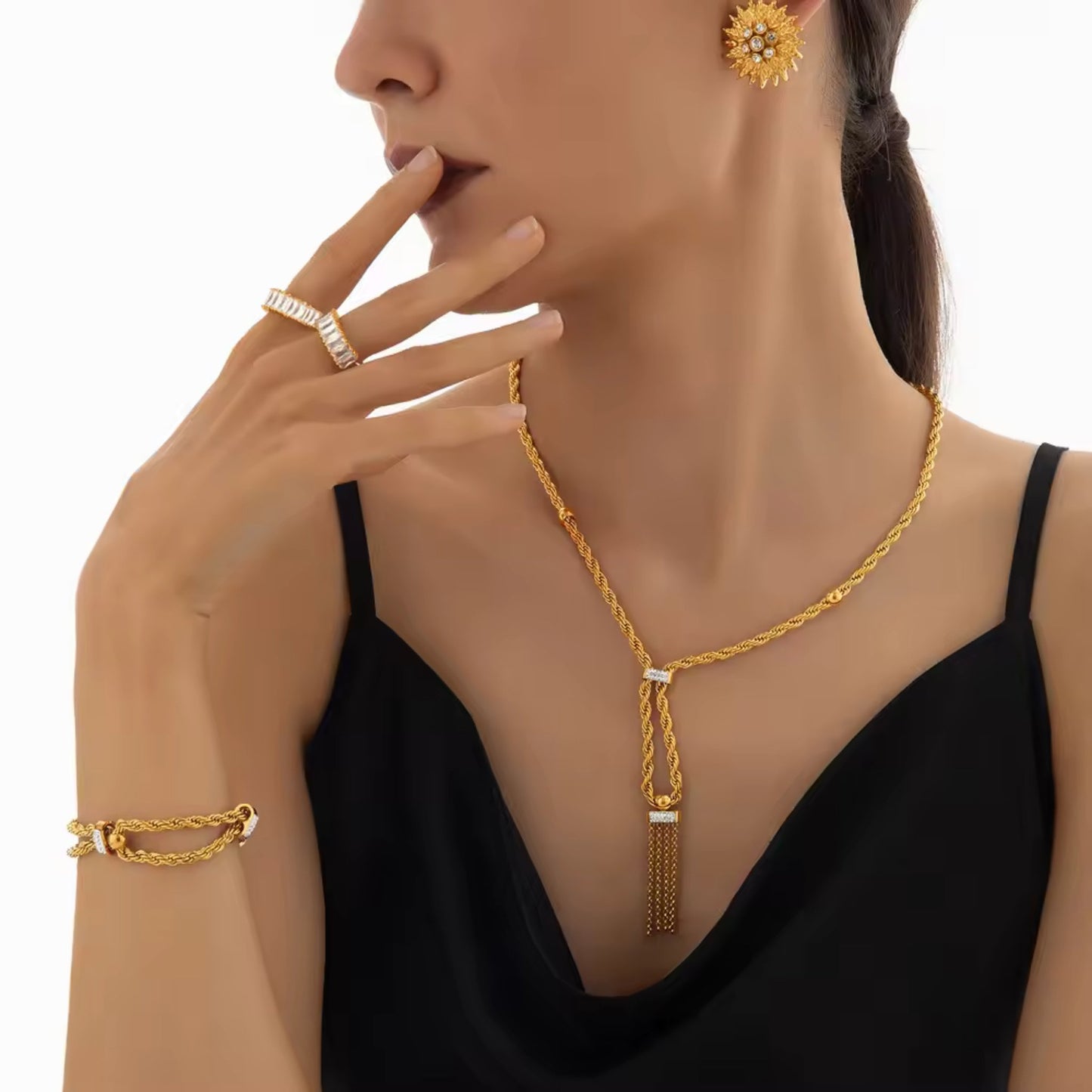 Model wearing the gold-plated necklace and bracelet set, styled with a formal outfit, highlighting its elegant tassel and rhinestone details.