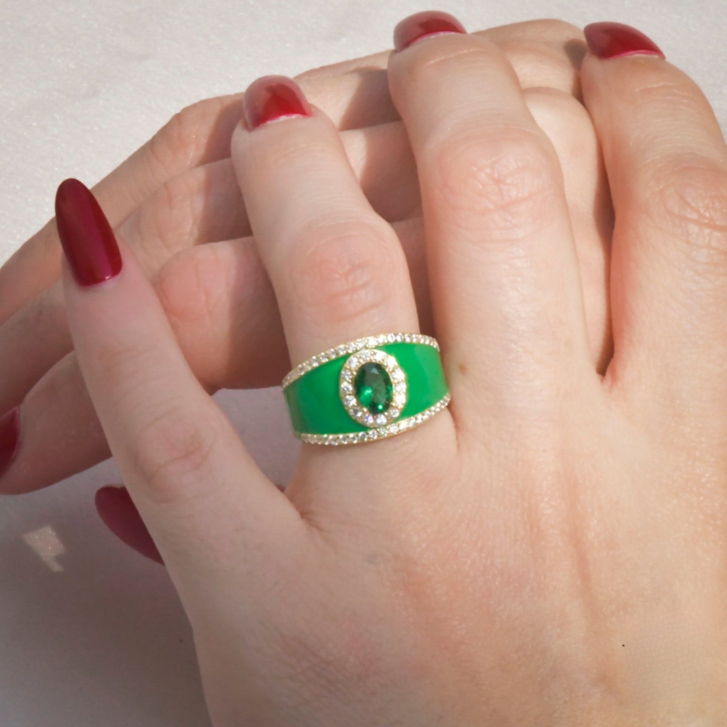 Model wearing the Emerald Enchantment Enamel Ring, emphasizing its bold green hue and elegant gold finish.