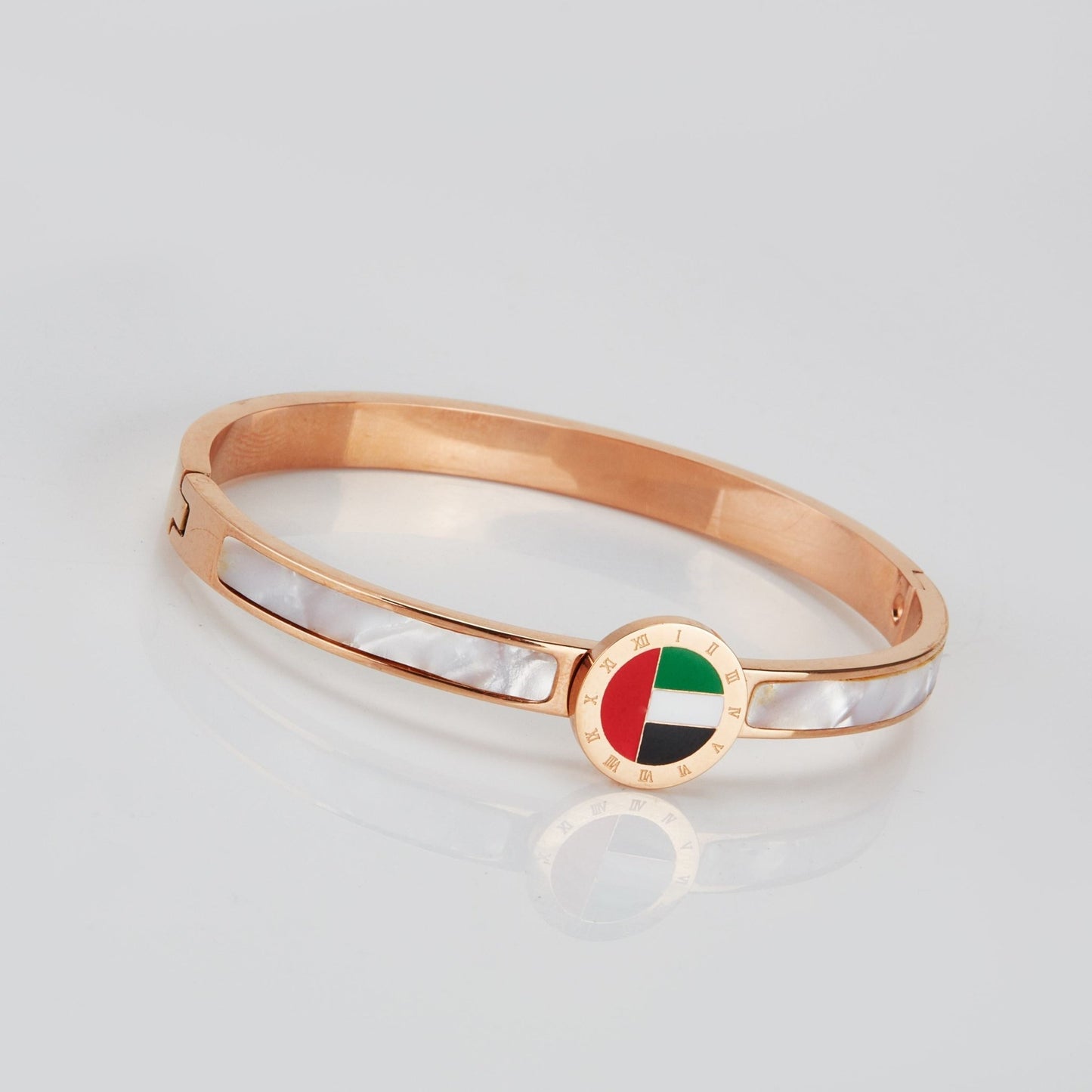 Emirates Pride Bangle featuring a round UAE flag charm and 18K rose gold plating, displayed on a white background.
