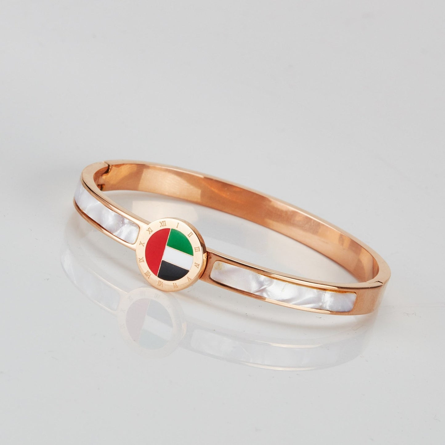 Emirates Pride Bangle featuring a round UAE flag charm and 18K rose gold plating, displayed on a white background.