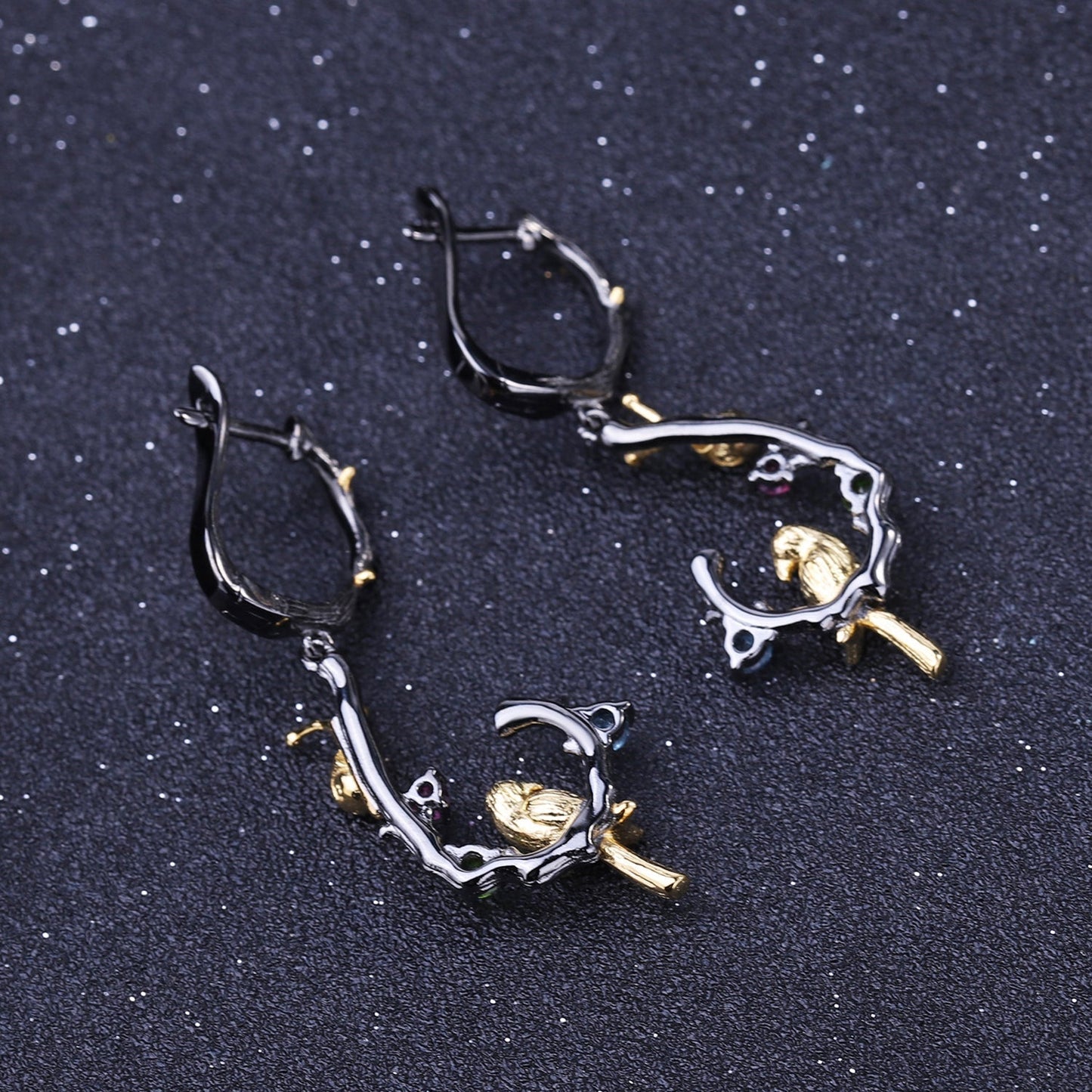 Detailed view of Swiss Blue Topaz, amethyst, and peridot stones on 925 Sterling Silver Bird & Snail Earrings with black gun and gold plating.