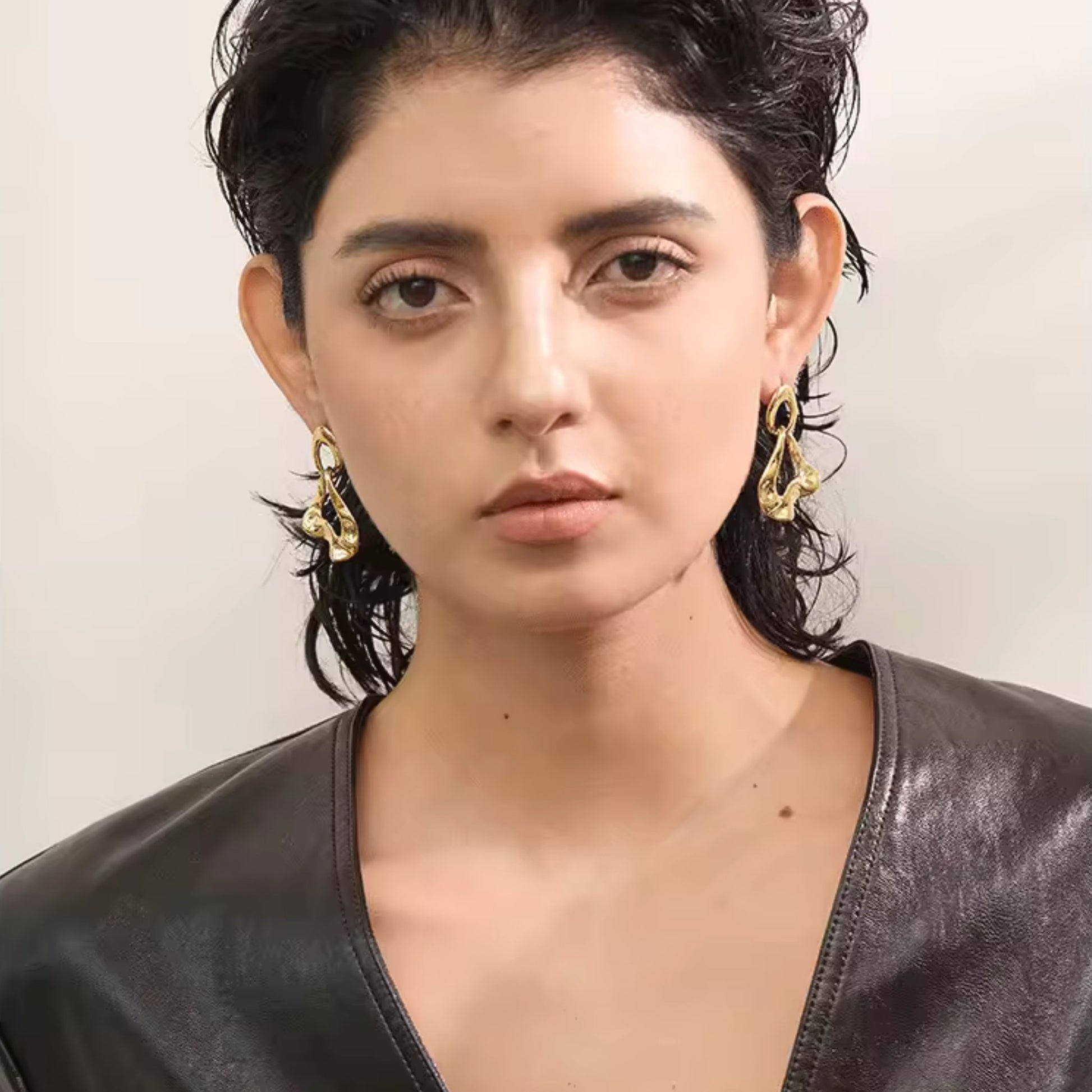 Abstract Luxe Gold Dangle Earrings styled with an evening outfit, adding artistic flair and bold elegance to the look.
