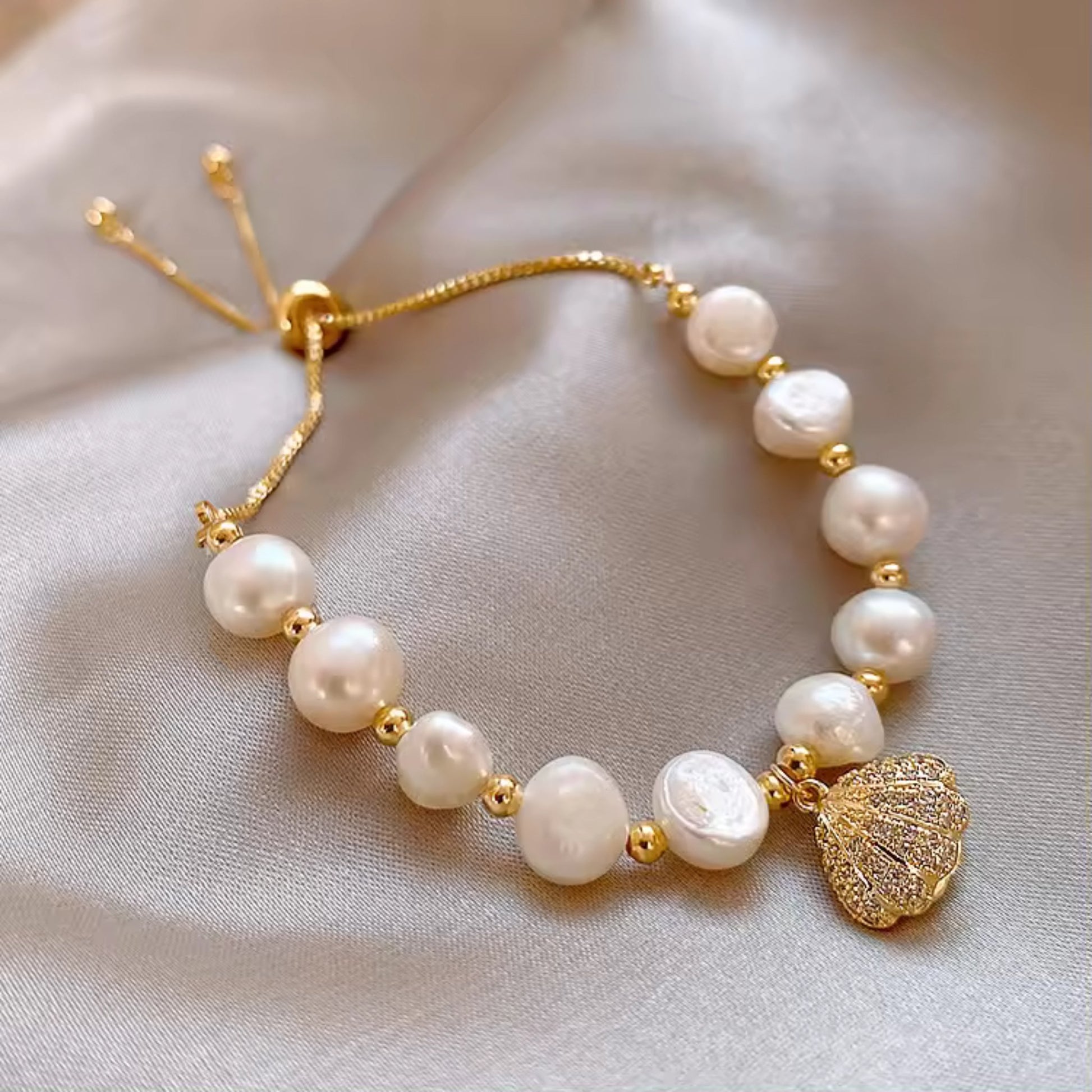 Close-up of Adjustable White Pearl Braided Bracelet featuring braided design, rhinestone inlays, and a shell charm.