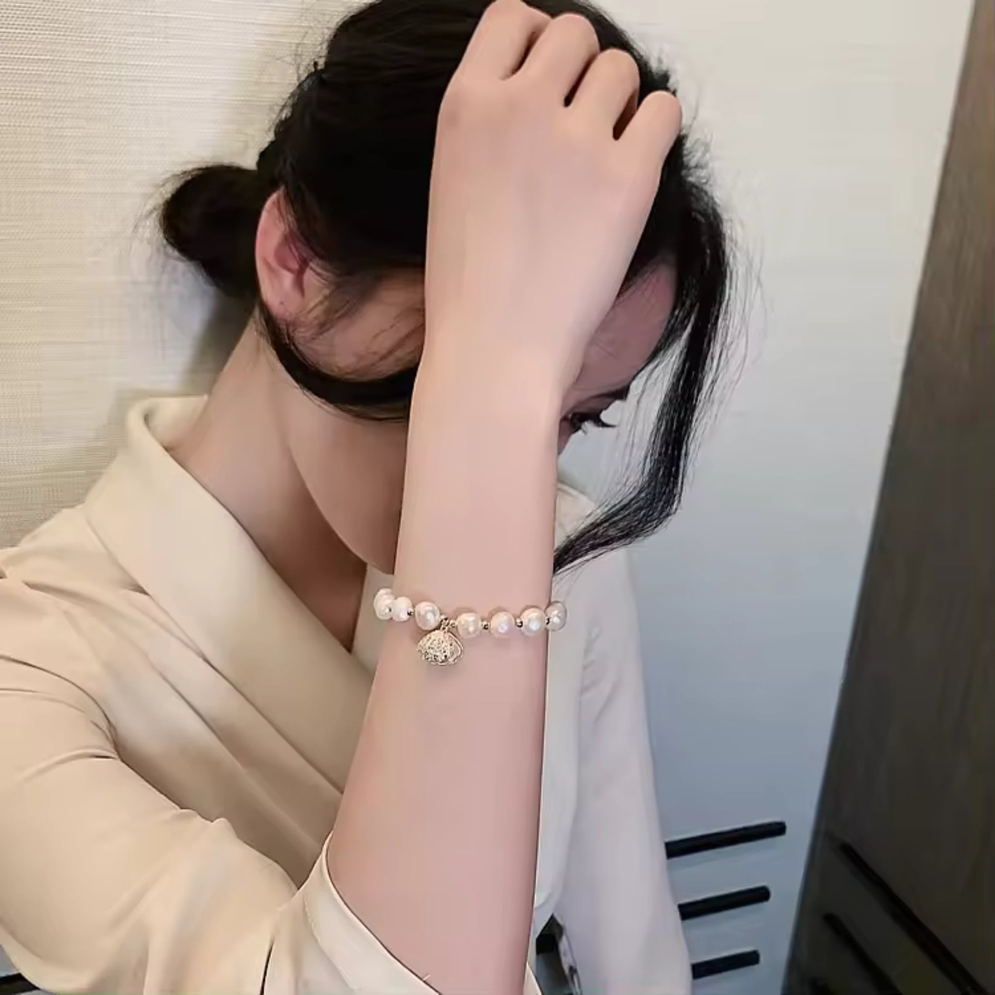 White Pearl Braided Bracelet styled on a wrist, showcasing its adjustable fit and luxurious design.