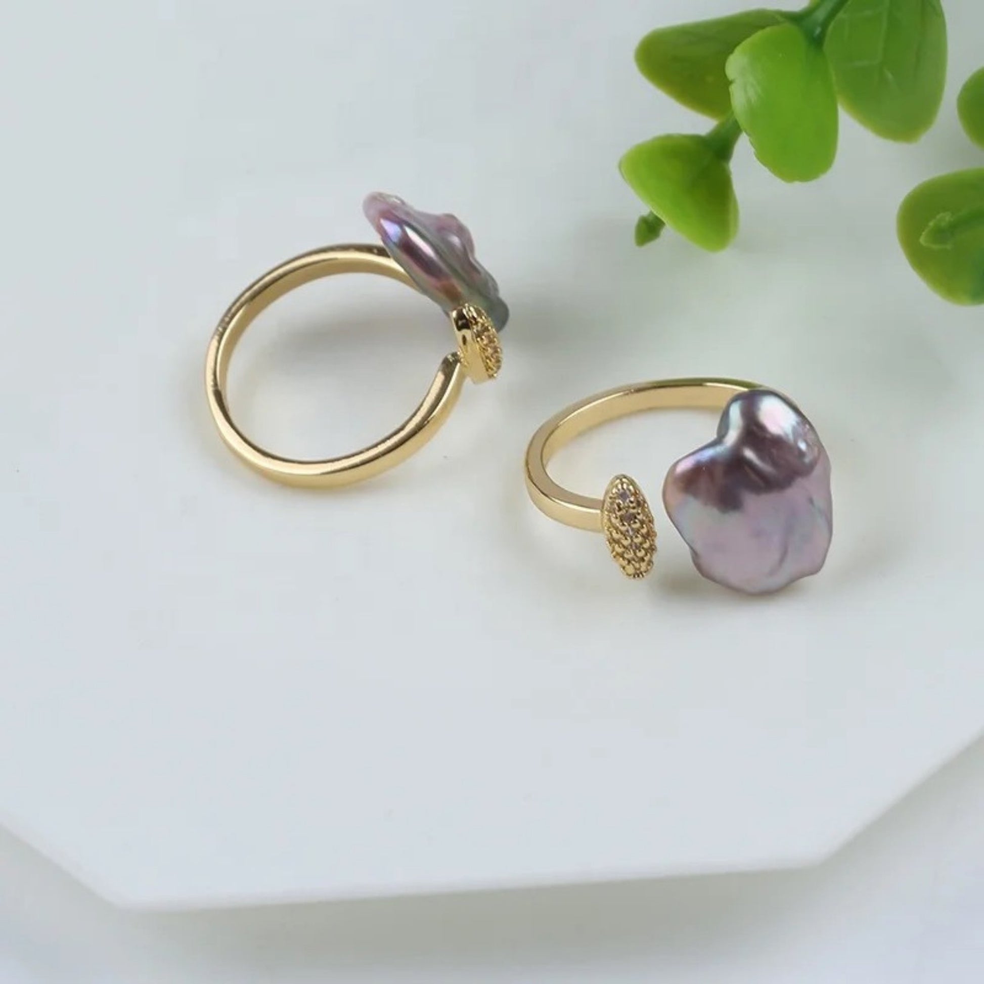 Close up of the Adjustable ring with an iridescent baroque freshwater pearl and a handcrafted wire-wrapped 18K gold-plated band.