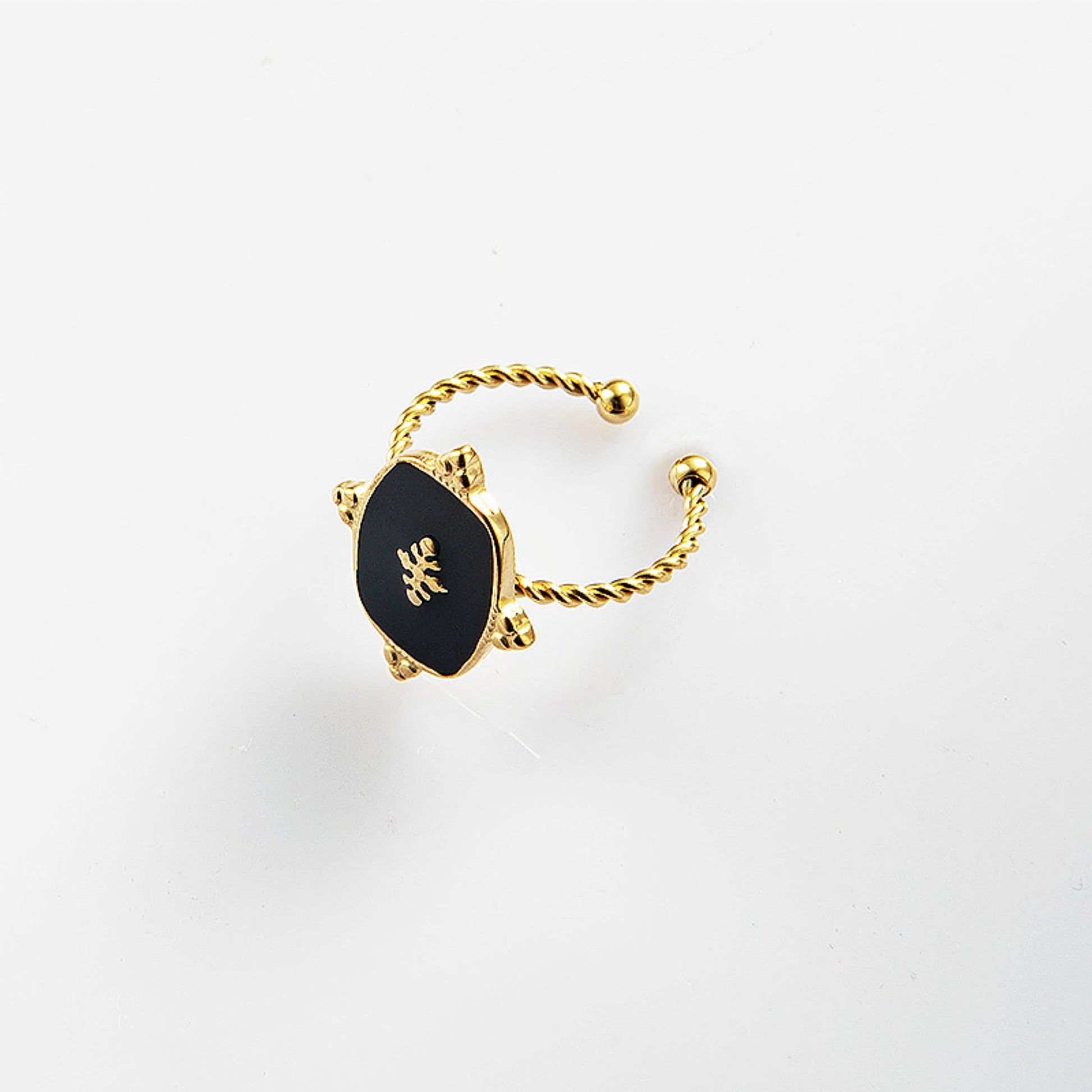 Close up of the Black Onyx Adjustable Gold Plated Ring with a 1.5 cm x 1.2 cm black onyx stone and a twisted gold-plated band, showcasing its timeless elegance.