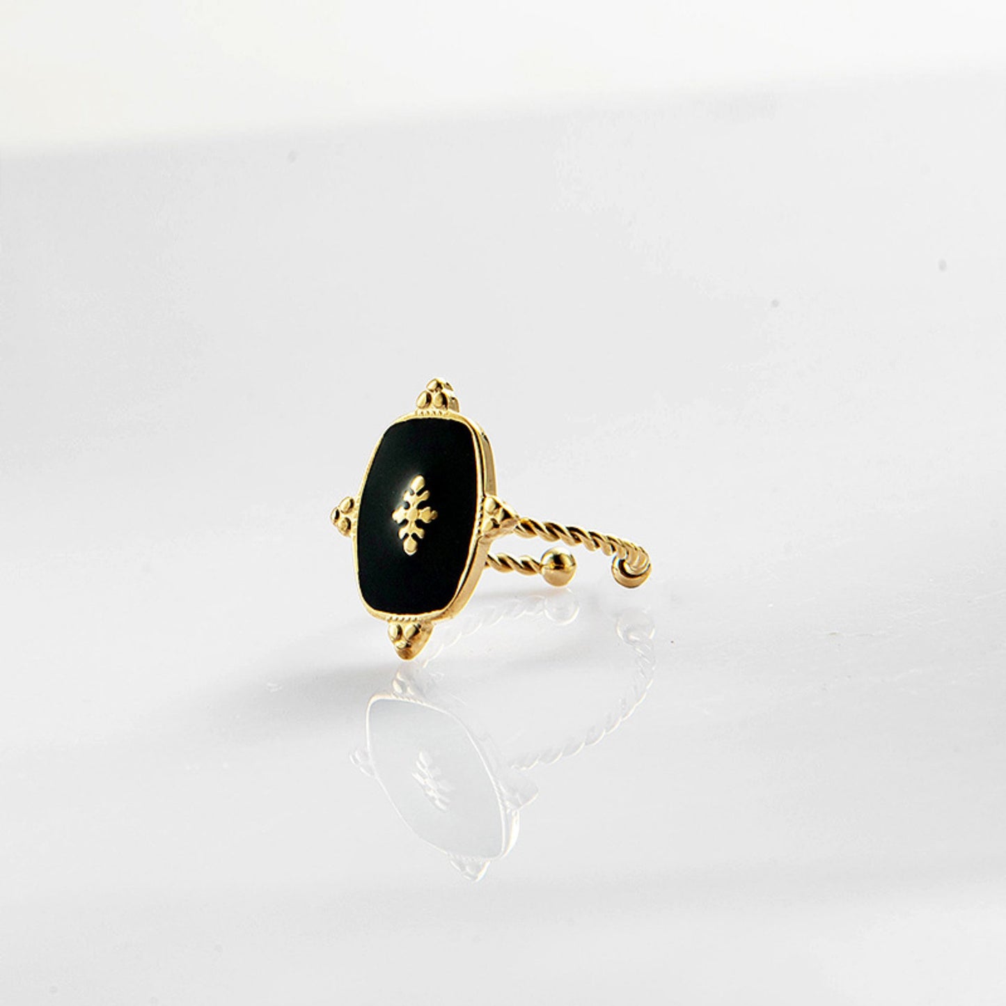Black Onyx Adjustable Gold Plated Ring with a 1.5 cm x 1.2 cm black onyx stone and a twisted gold-plated band, showcasing its timeless elegance.