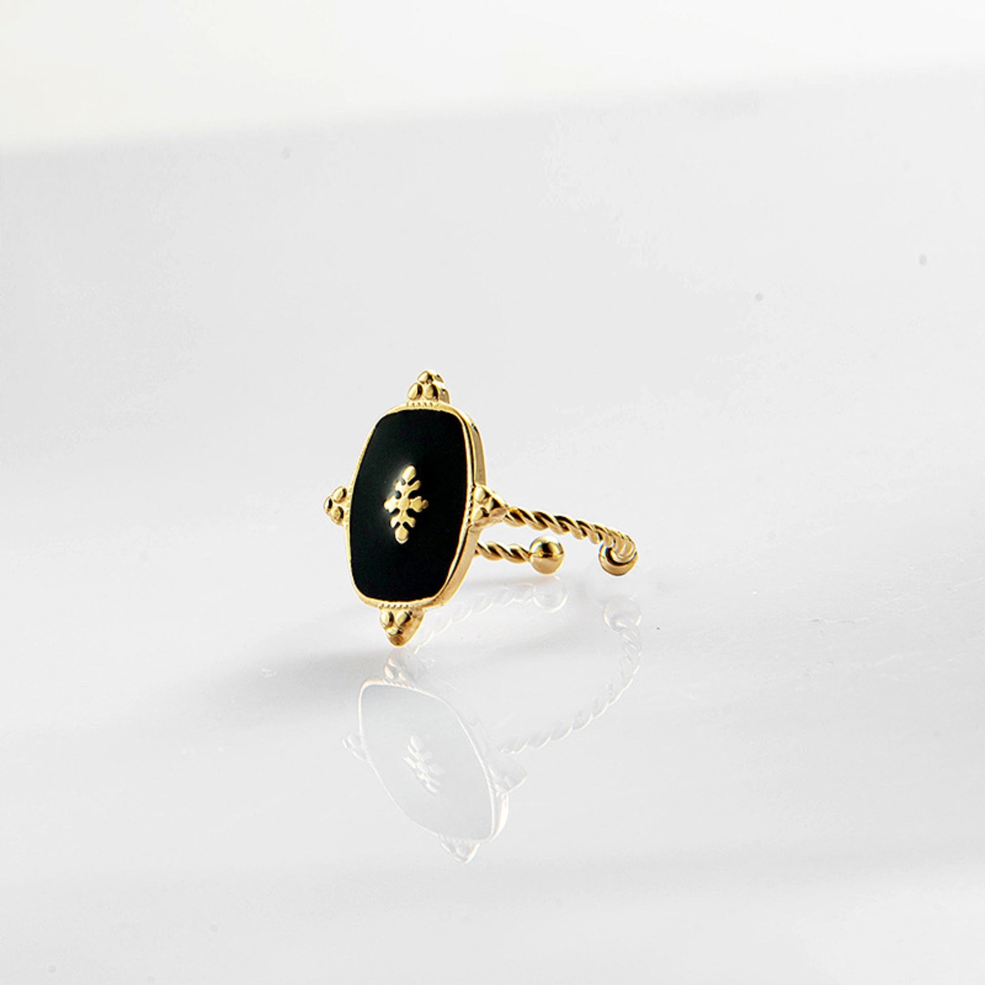 Black Onyx Adjustable Gold Plated Ring with a 1.5 cm x 1.2 cm black onyx stone and a twisted gold-plated band, showcasing its timeless elegance.