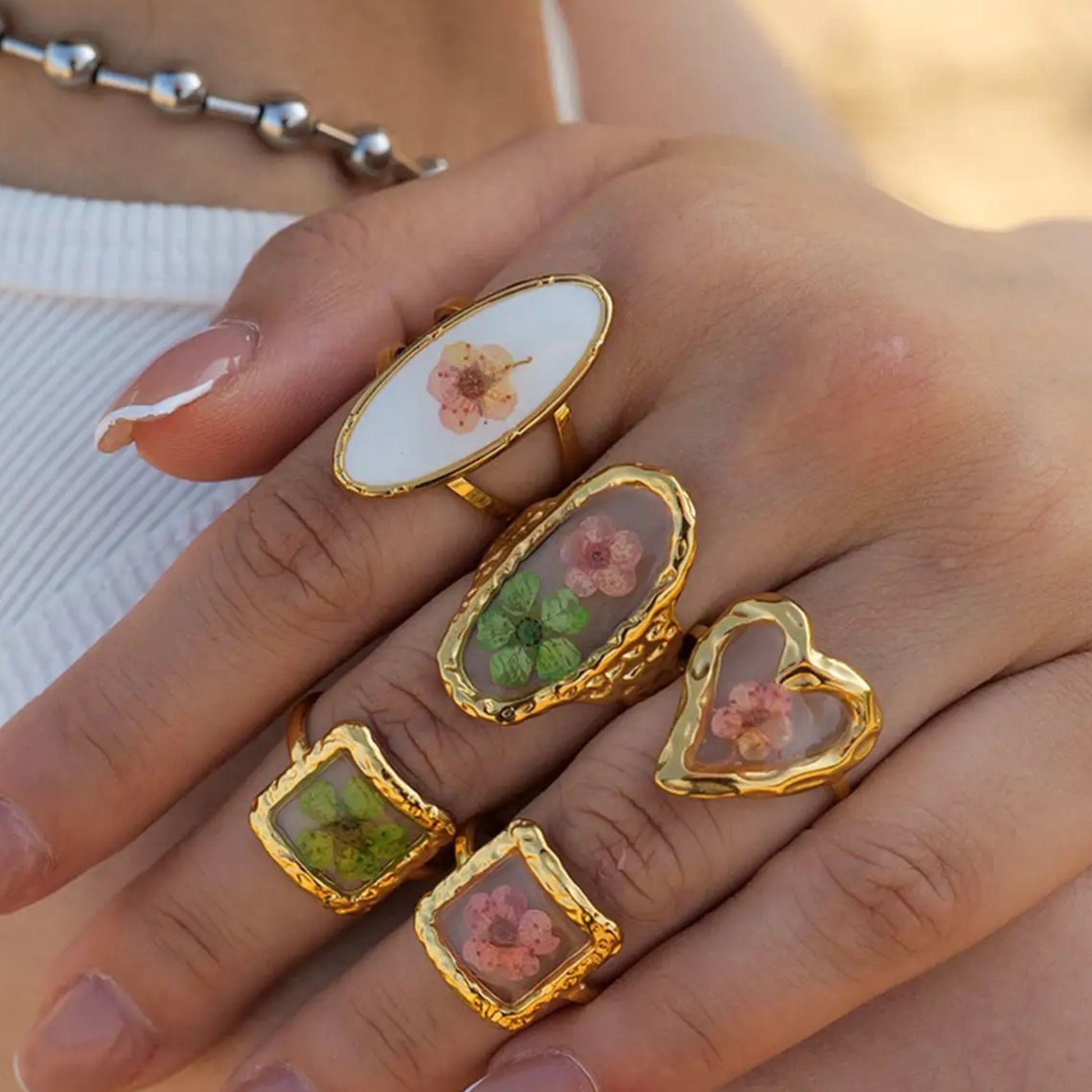 Blooming Elegance Floral Open Ring with an oval floral motif styled on a model's hand, showcasing its adjustable and dainty design.