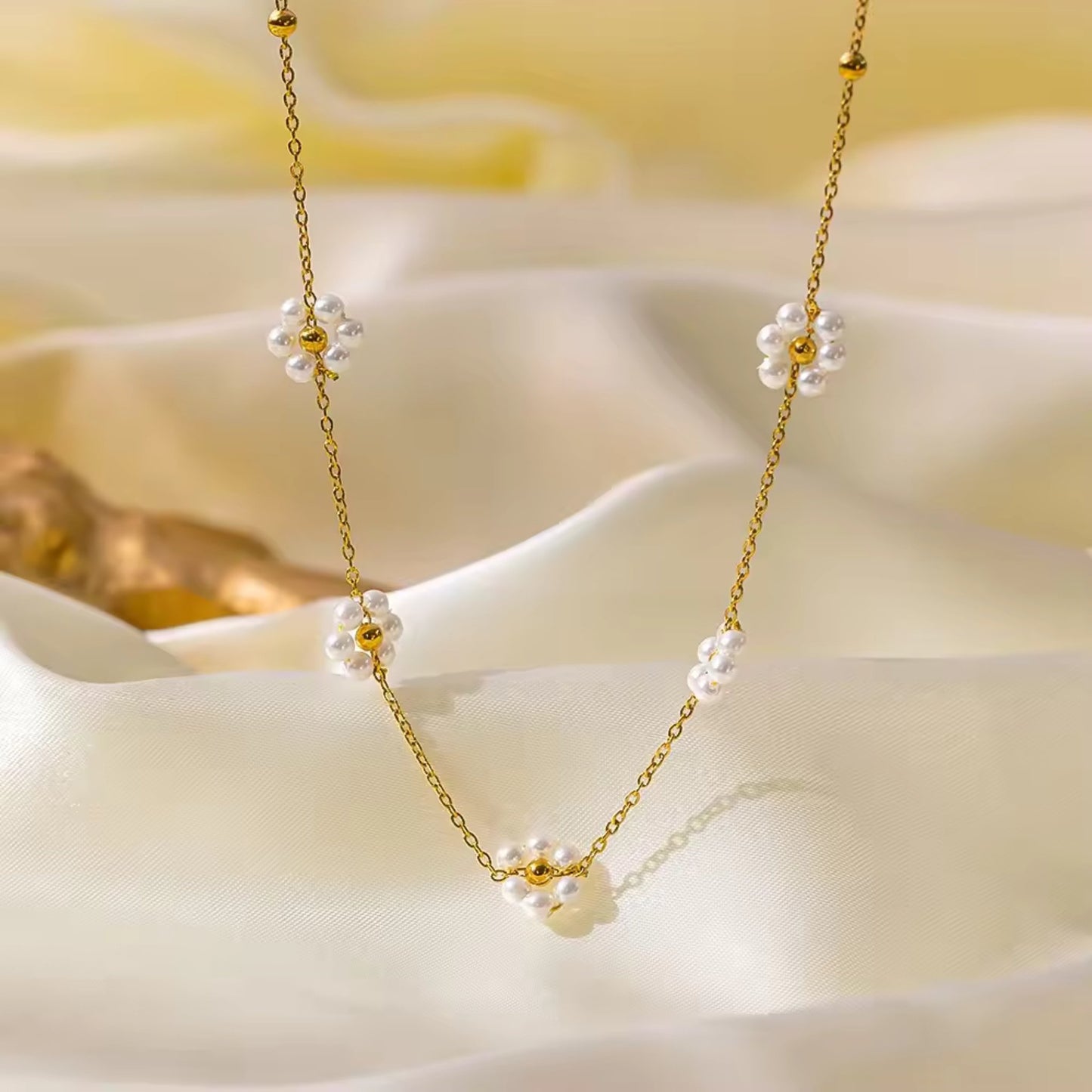 Close-up of Blossom Elegance Pearl Necklace featuring intricately designed floral accents with lustrous pearls in an 18K gold-plated finish.