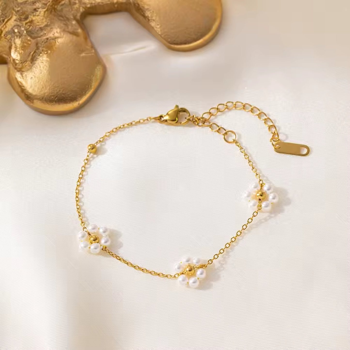Close-up of Blossom Elegance Pearl Bracelet featuring intricately designed floral accents with lustrous pearls in an 18K gold-plated finish.