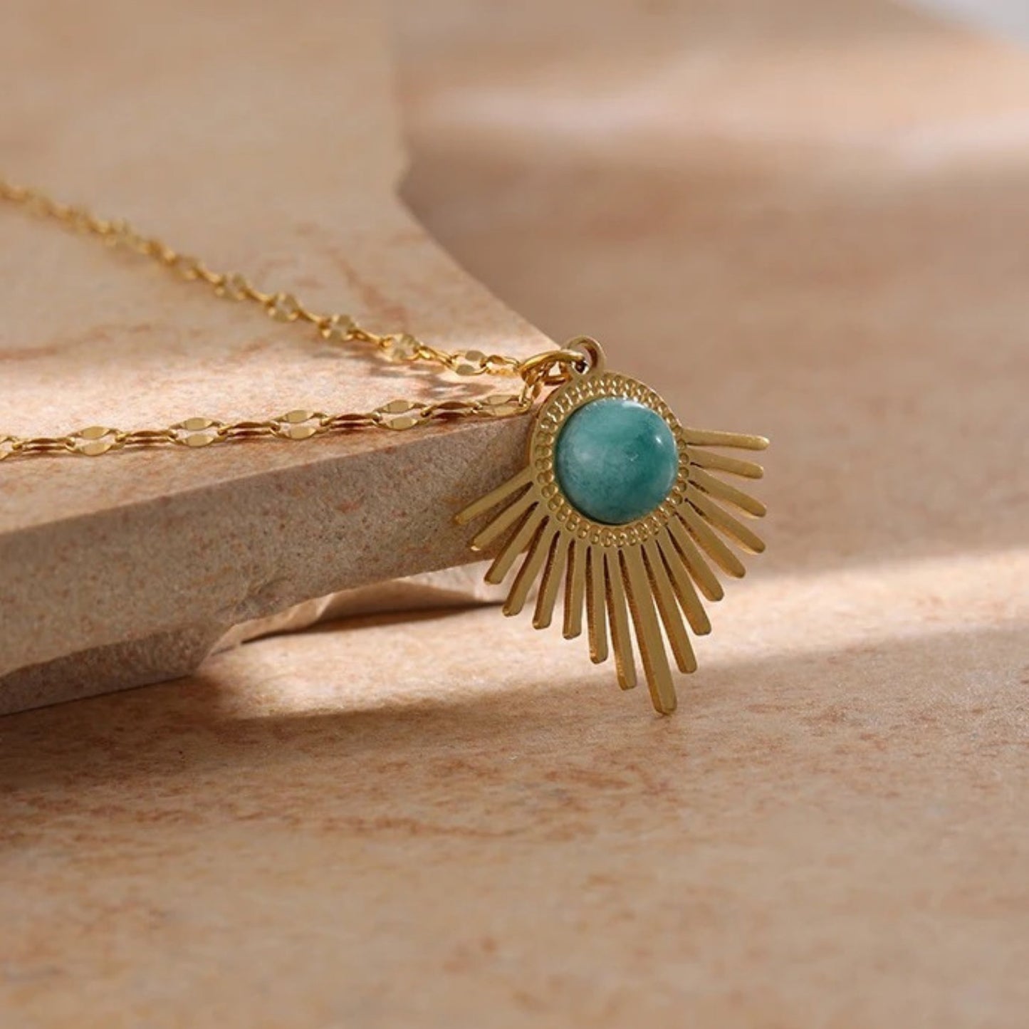Close up of the Bohemian Radiance Necklace with a radiant 18K gold-plated pendant and natural turquoise stone, offering summer bohemian elegance.