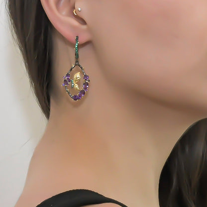 Amethyst and Emerald Sterling Silver Earrings styled on a model, highlighting their elegant branch motif and vibrant gemstones.