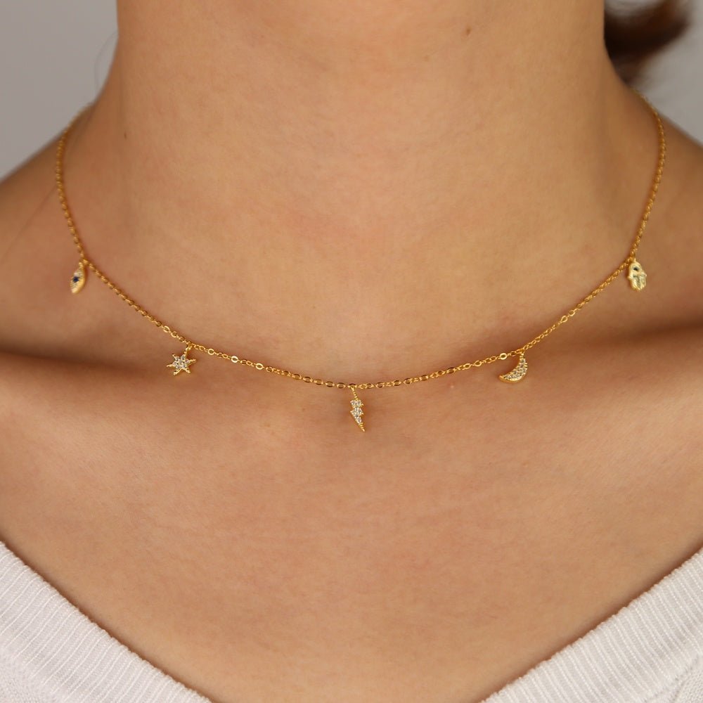 Celestial Charm Necklace styled on a model, showcasing its enchanting 18K gold-plated charms and sparkling zircon stones.