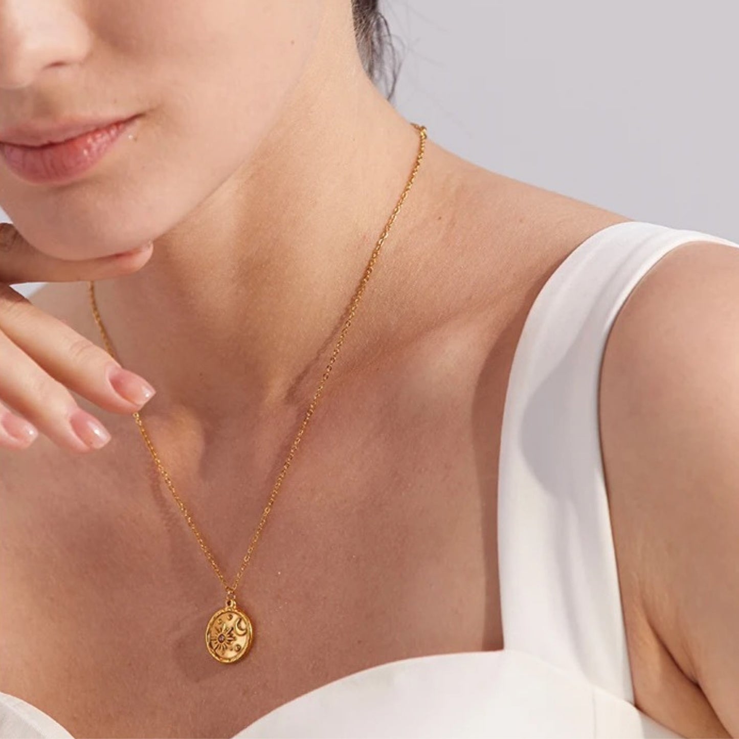 Celestial Sun and Moon Pendant Necklace styled on a model, showcasing its elegant sun and moon design and 18K gold-plated finish