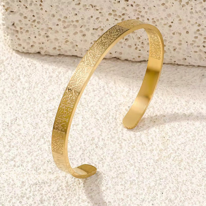 Close-up of the engraved Al Kursi Verse on the 18K gold-plated open cuff bangle.