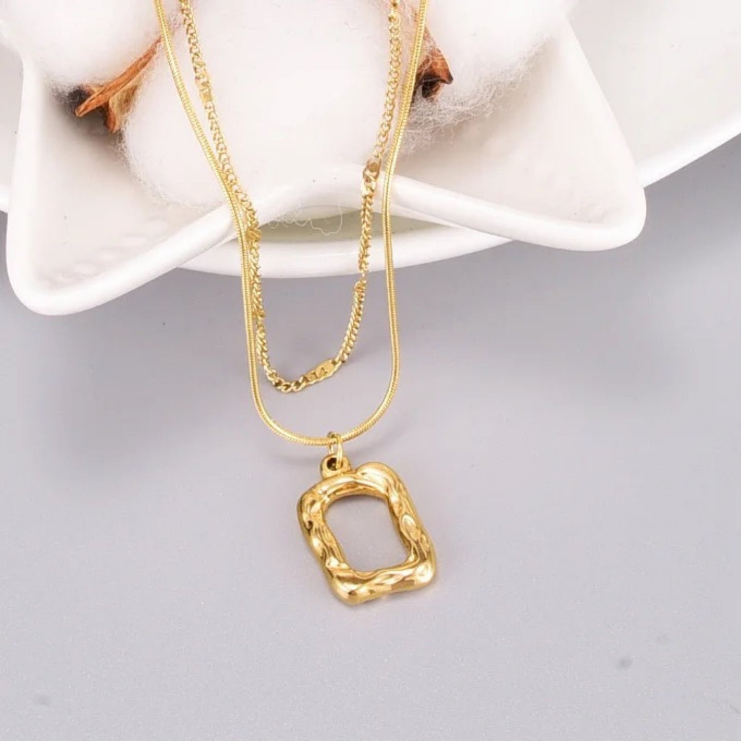 Close-up of the irregular rectangular pendant on the Dual Layer Necklace with 18K gold plating.