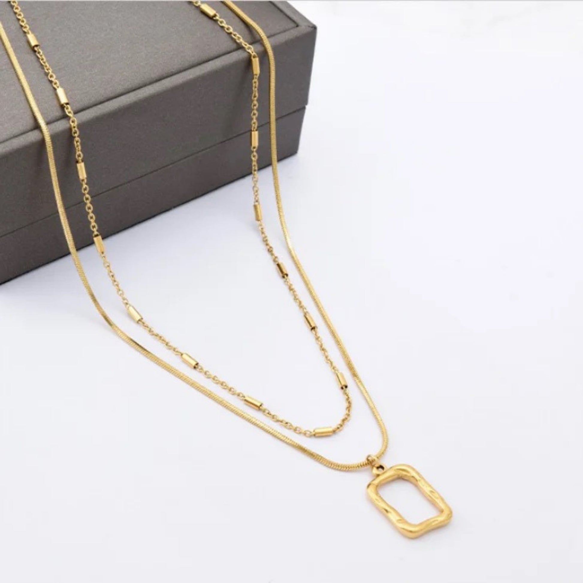 Close-up of the irregular rectangular pendant on the Dual Layer Necklace with 18K gold plating.
