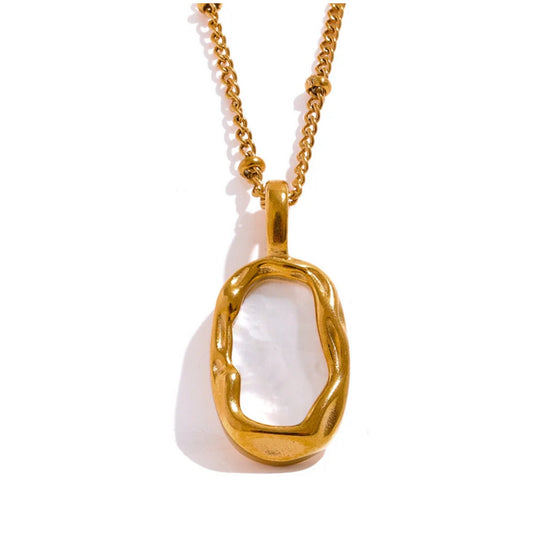 Close-up of the double-sided shell pendant, showcasing its intricate design and luxurious gold finish.