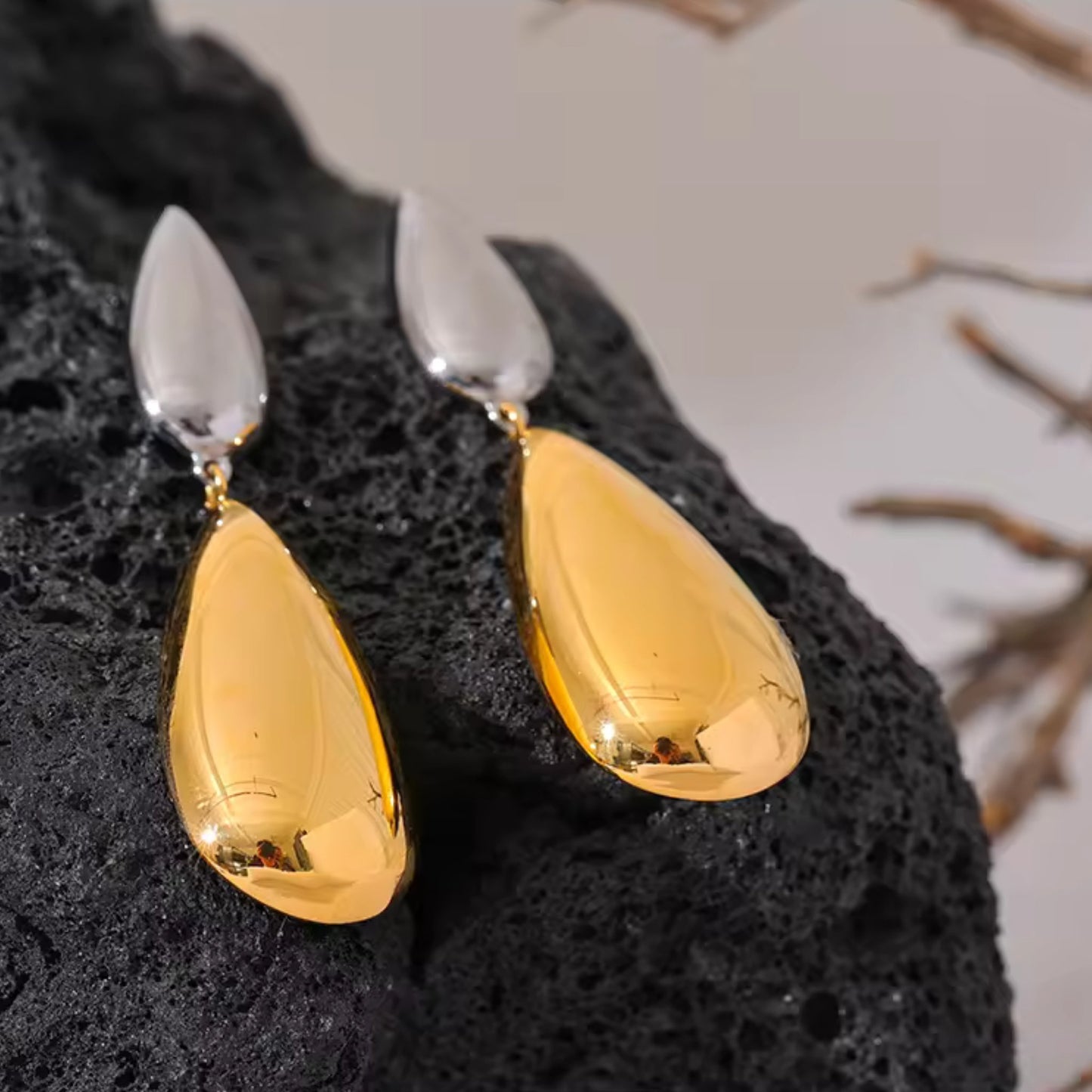 Flat-lay of Dual-Tone Drop Earrings, emphasizing the sleek combination of silver and gold tones.