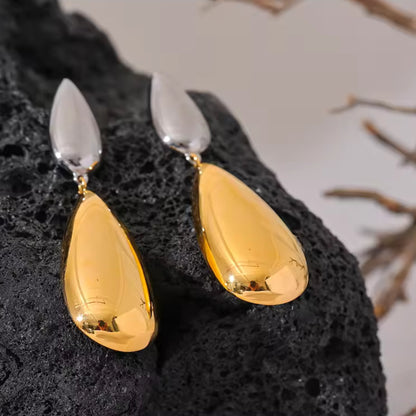 Flat-lay of Dual-Tone Drop Earrings, emphasizing the sleek combination of silver and gold tones.