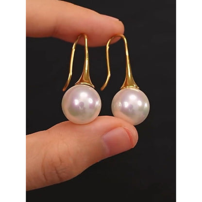 Holding the Gold Elegance Pearl Drop Earrings, perfect for Everyday use