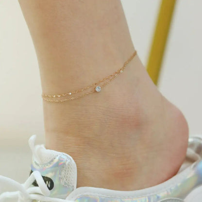 Model wearing the Elegant Double Layer Anklet with white zircon, styled with casual summer attire.