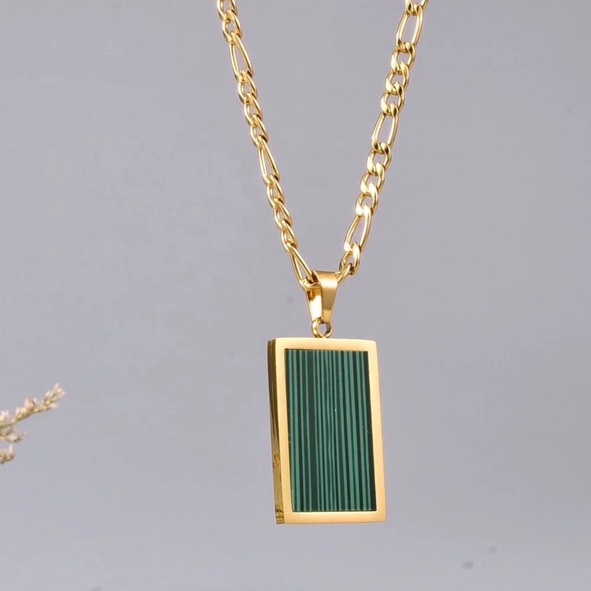 Close-up of an 18K gold-plated rectangular pendant necklace featuring vibrant green malachite on a delicate stainless steel chain.