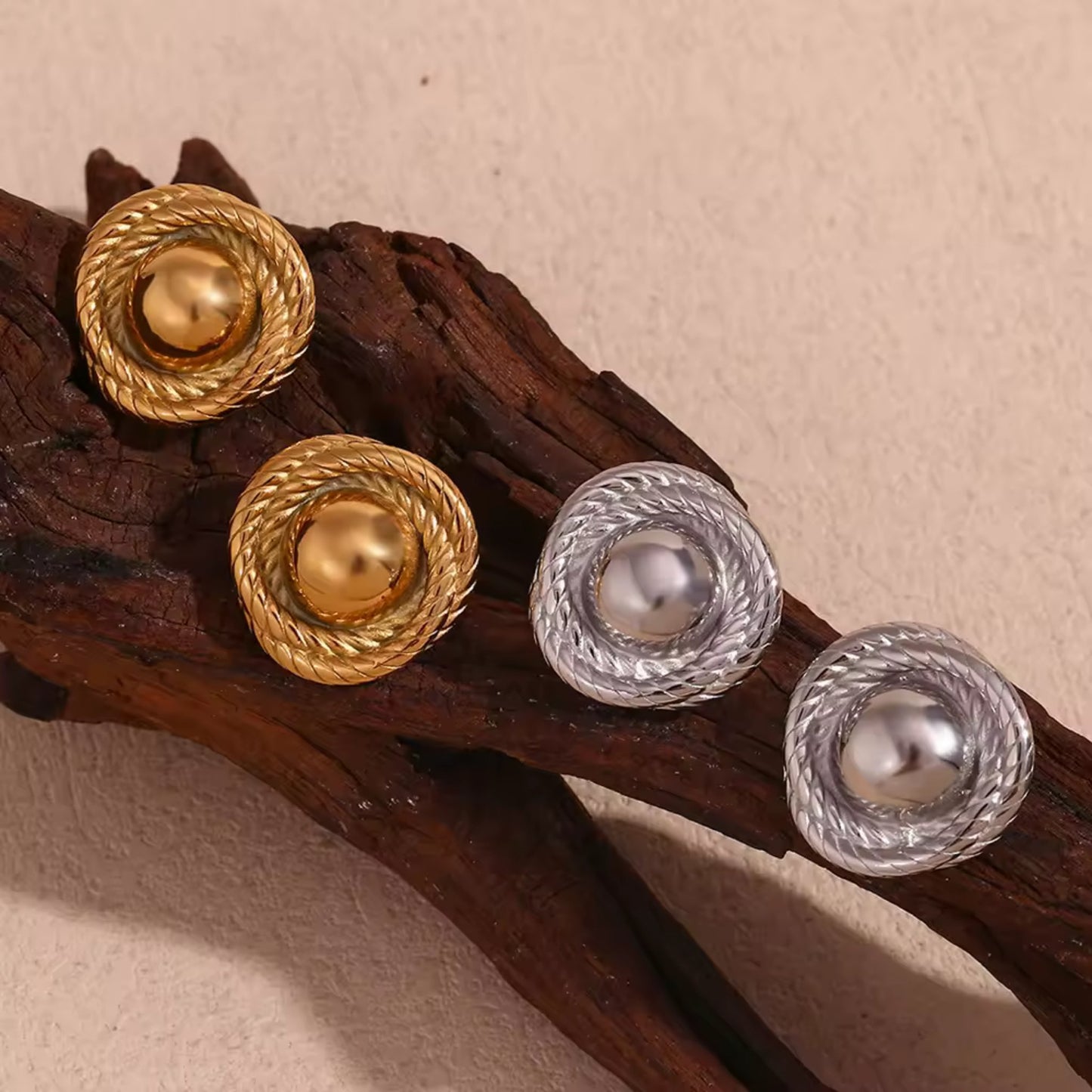 Gold and silver twist hoop earrings elegantly presented, showcasing their unique craftsmanship.