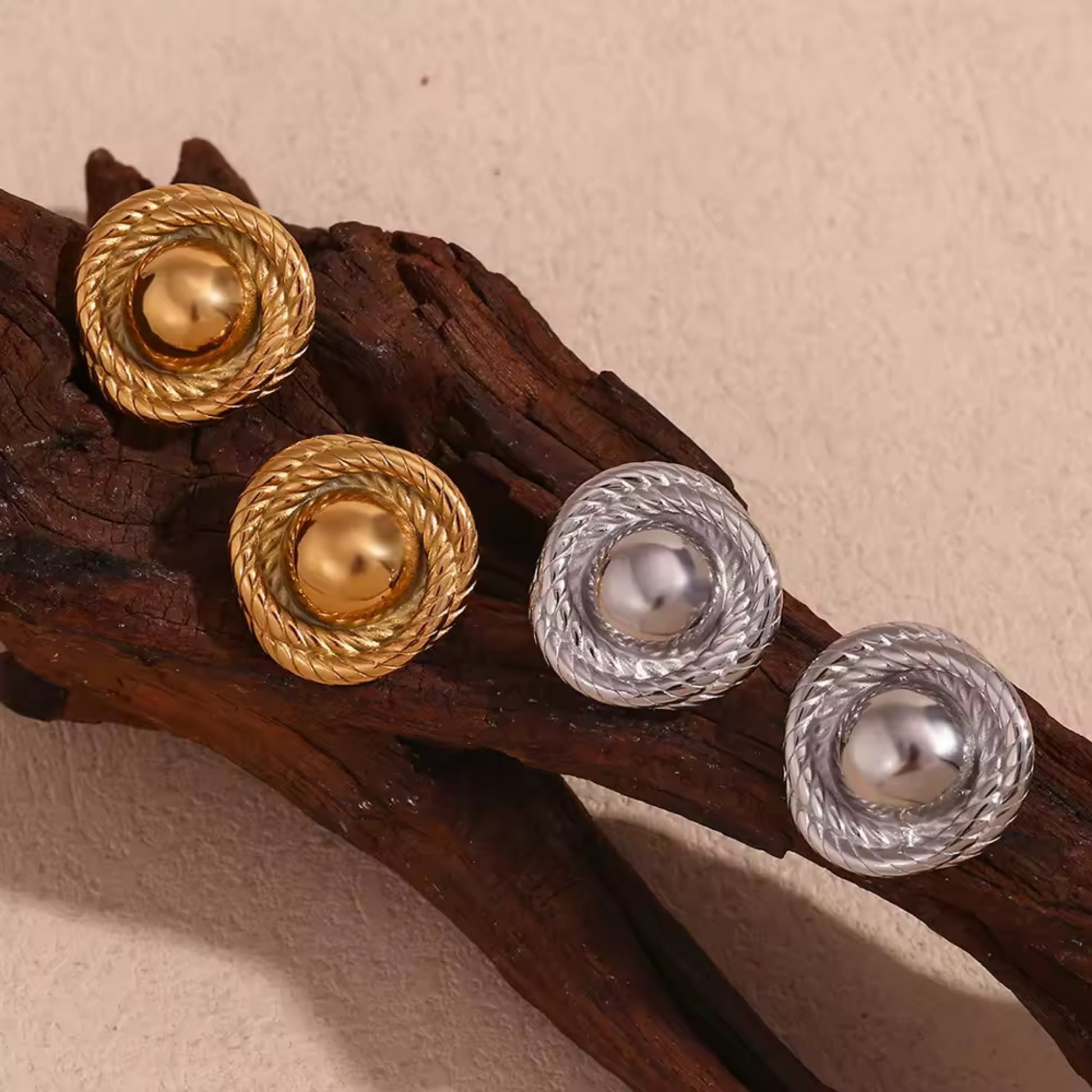 Gold and silver twist hoop earrings elegantly presented, showcasing their unique craftsmanship.