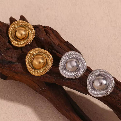 Gold and silver twist hoop earrings elegantly presented, showcasing their unique craftsmanship.