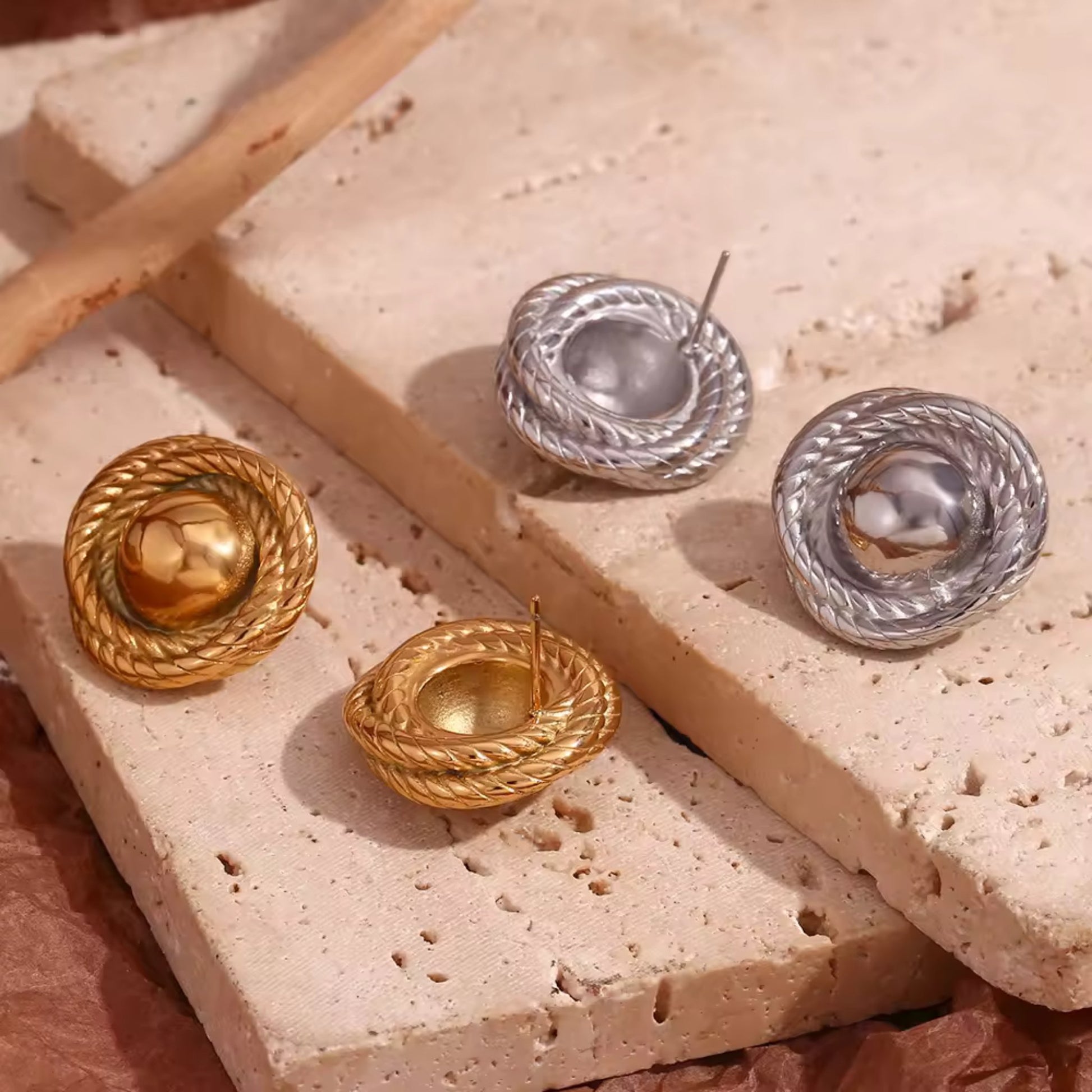 Side-by-side image of gold and silver twist hoop earrings, highlighting their timeless and versatile design.