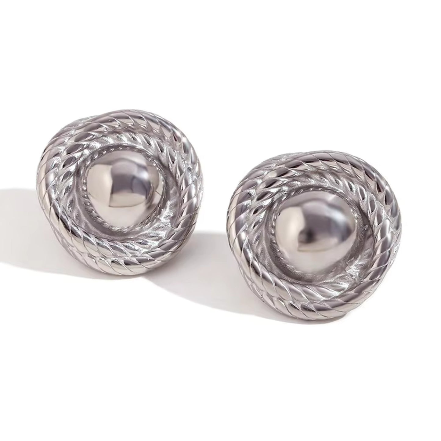 Elegant silver-plated twist hoop earring with a unique design, photographed against a white background.