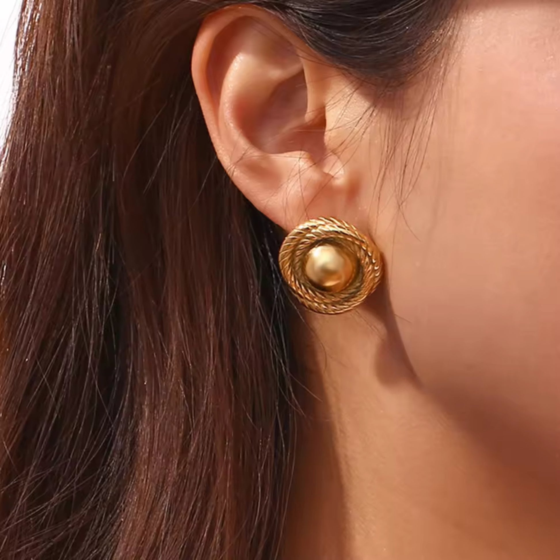 Model showcasing gold-plated twist hoop earrings, styled with a chic evening outfit for a luxurious look.